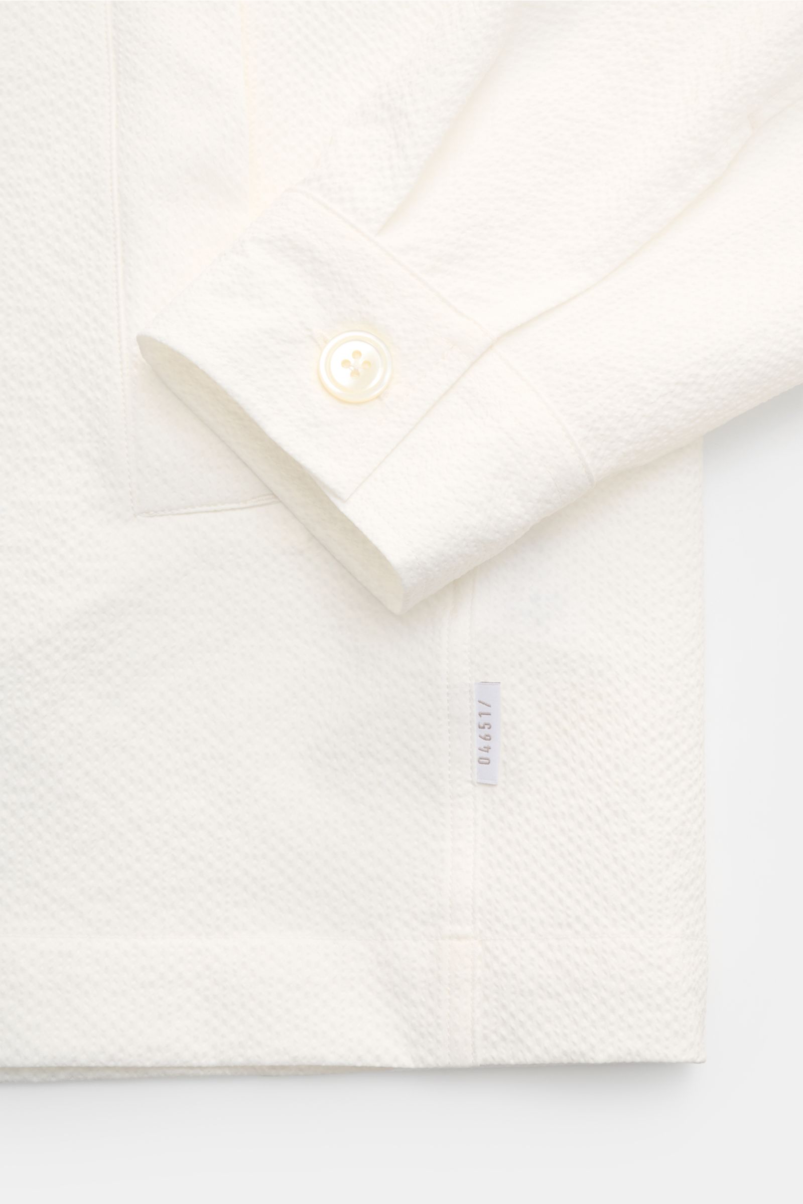 Off-white 04651/ A trip in a bag Overshirt 'Technical Seersucker' close-up from front side showing textured microfibre, slim fit, five-button placket, turn-down collar, and jetted pockets. Textured holiday essential: This seersucker overshirt by 04651/ A 