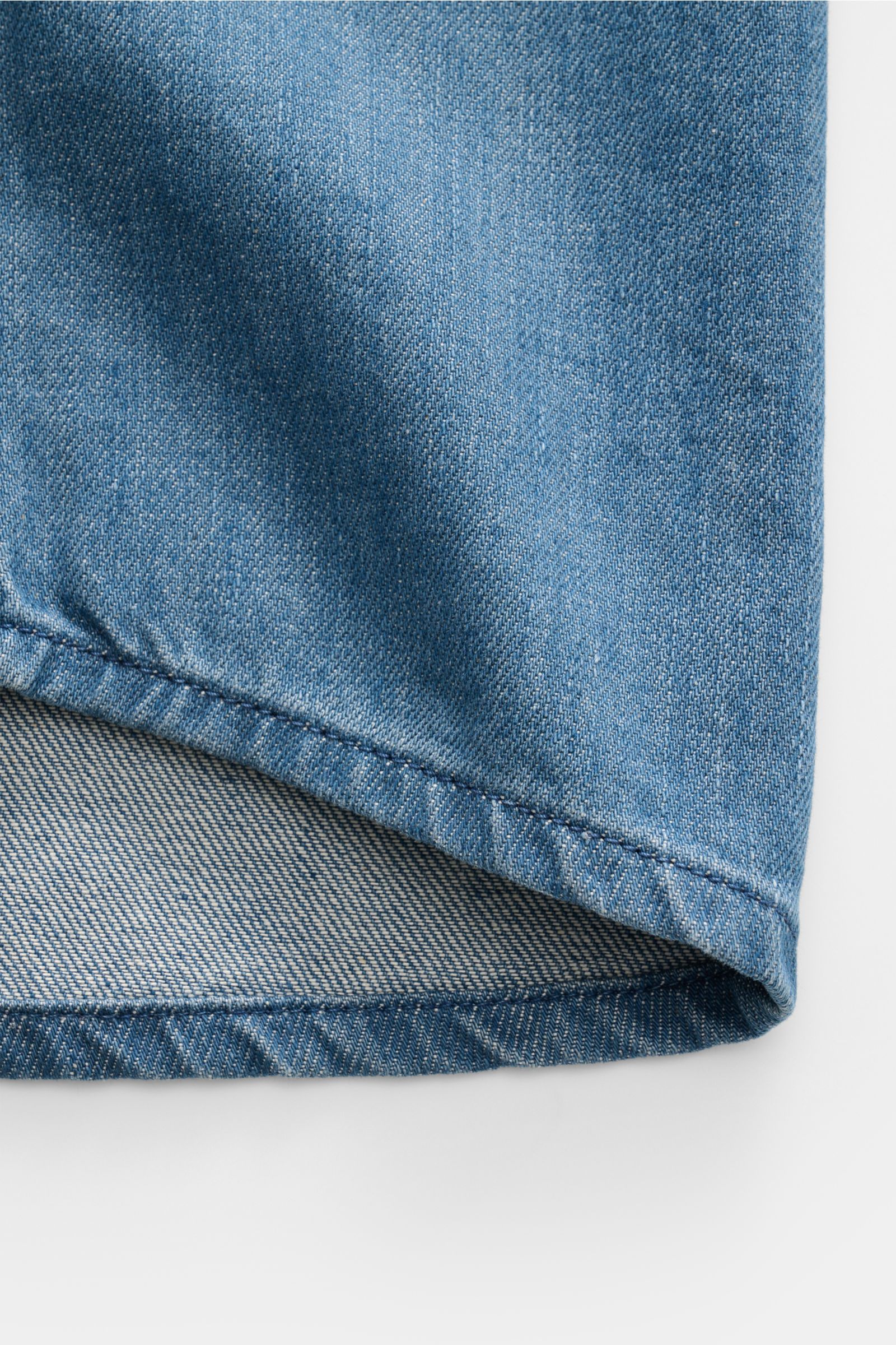 Ausschnitt des A.P.C. Jeans-Overshirt rauchblau aus reiner Baumwolle, Slim Fit, Kent-Kragen, Knopfleiste, Brusttaschen, Sportmanschette, Detailansicht.