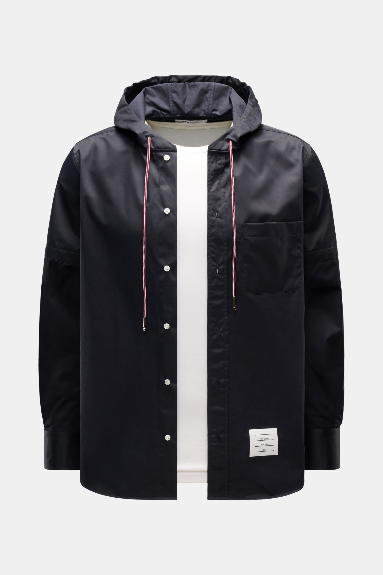 Front view of the Thom Browne Overshirt - F1066 in black with a hood and white inner shirt, featuring a mix of cotton and microfiber, slim fit, button placket, chest pocket, drawstring hood, and cuffed sleeves; smooth texture and versatile sporty-function