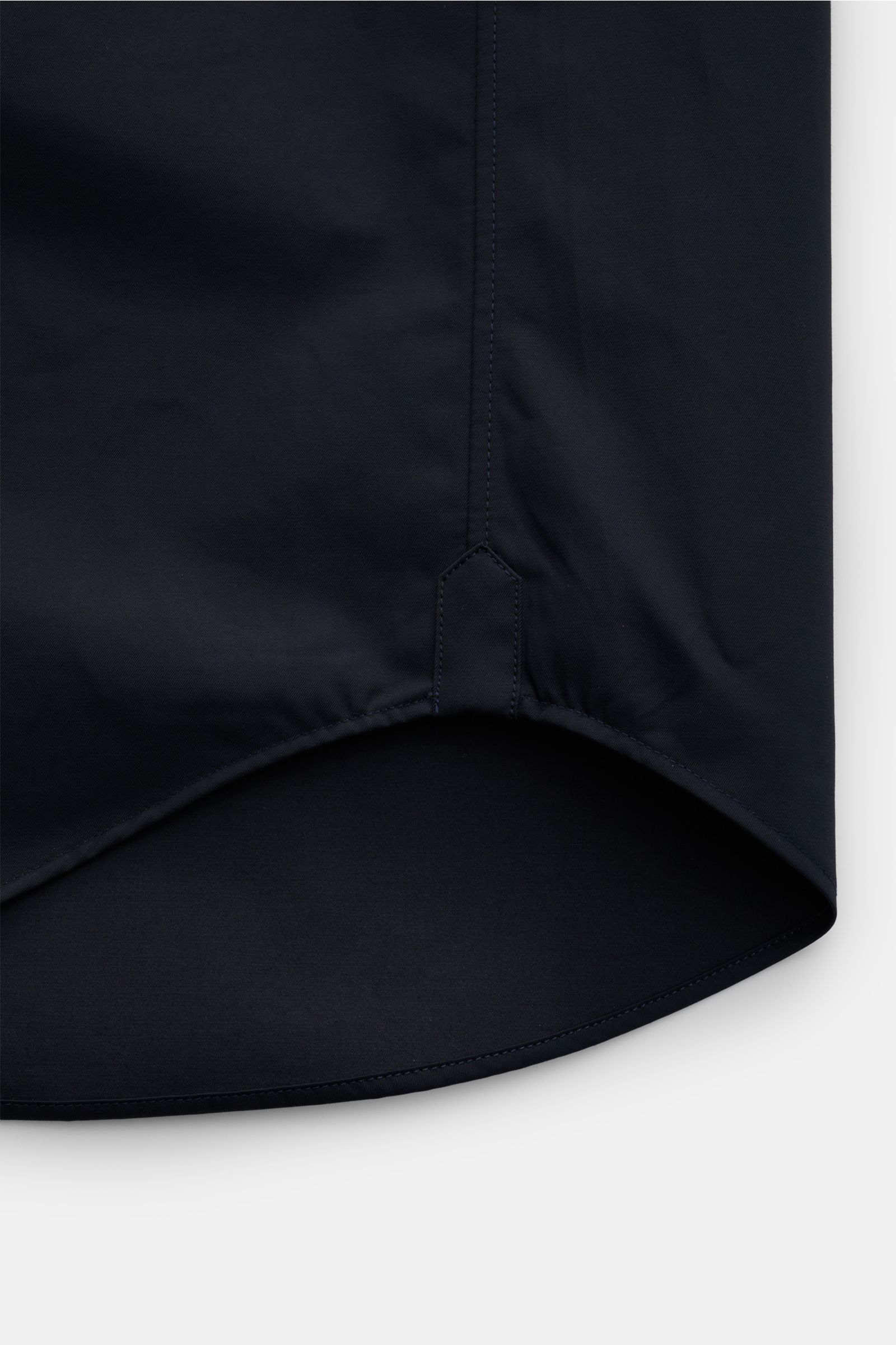 Close-up view of the curved hem detail on the dark fabric of the Thom Browne Overshirt - F1066, showcasing fine stitching and smooth texture.

Luxuriöses Layering-Piece: Das Overshirt von THOM BROWNE überzeugt mit seinem sportiv-funktionalen Design und