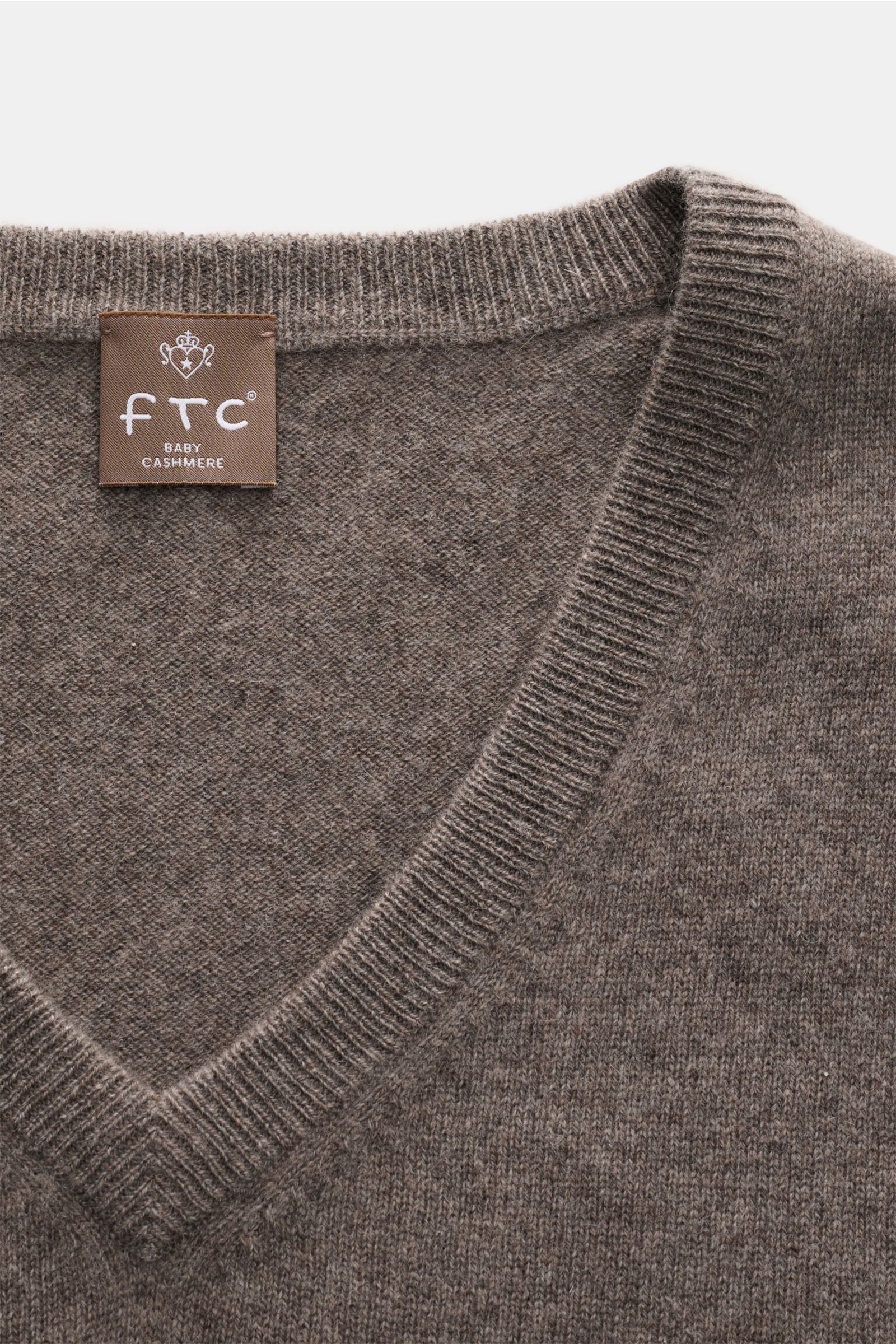 Close-up front view of the FTC Baby-Cashmere V-Neck Pullover graubraun meliert showing the V-neckline and fine knit texture in grey-brown melange.

Der Pullover mit V-Ausschnitt ist ein Klassiker der Herrenmode, der in keinem Kleiderschrank fehlen darf
