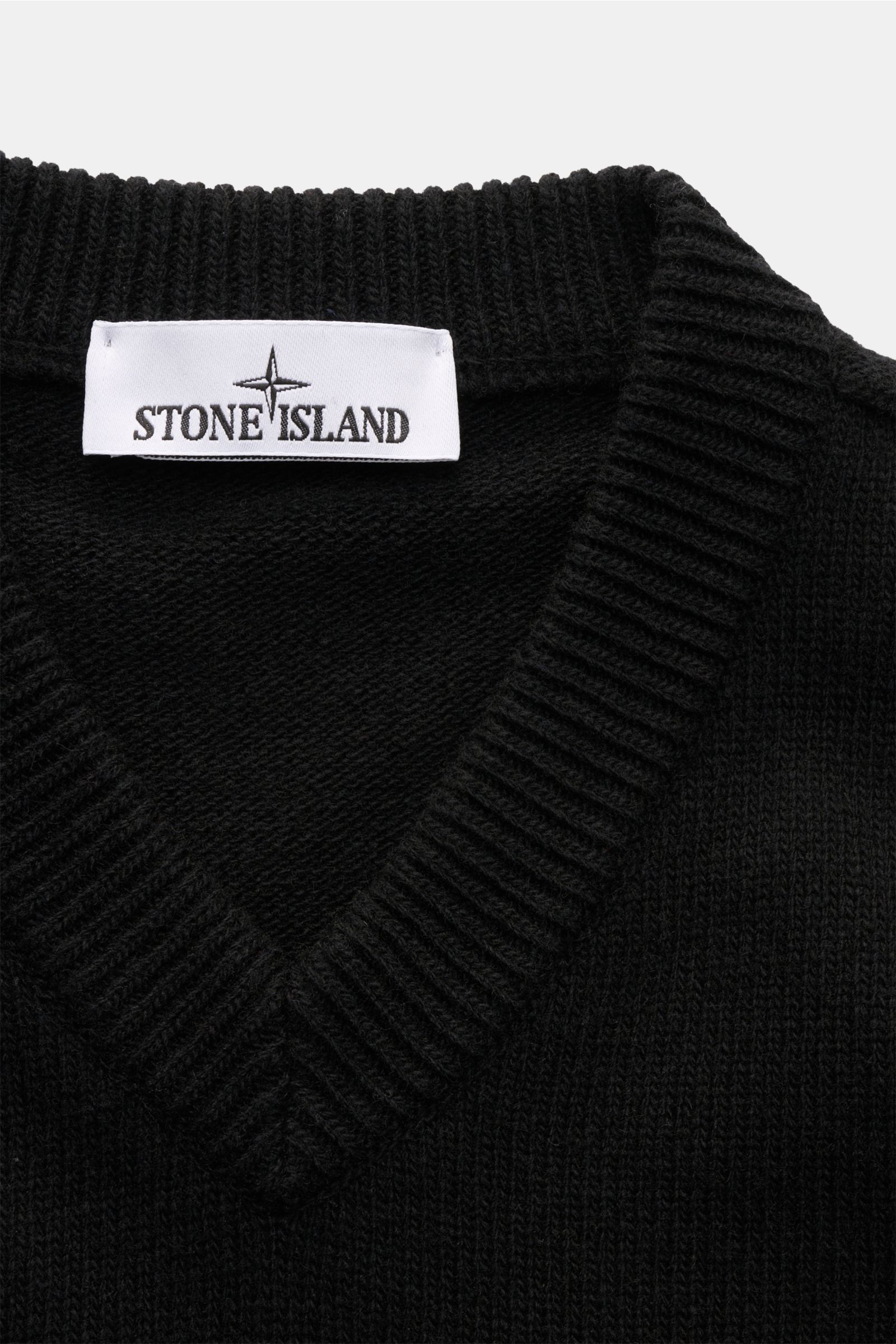 Stone Island V-Neck Pullover 'Lambswool' schwarz, Nahaufnahme von V-Ausschnitt mit weichem Wollmix, Linksstrick und Rippbündchen, Label sichtbar.