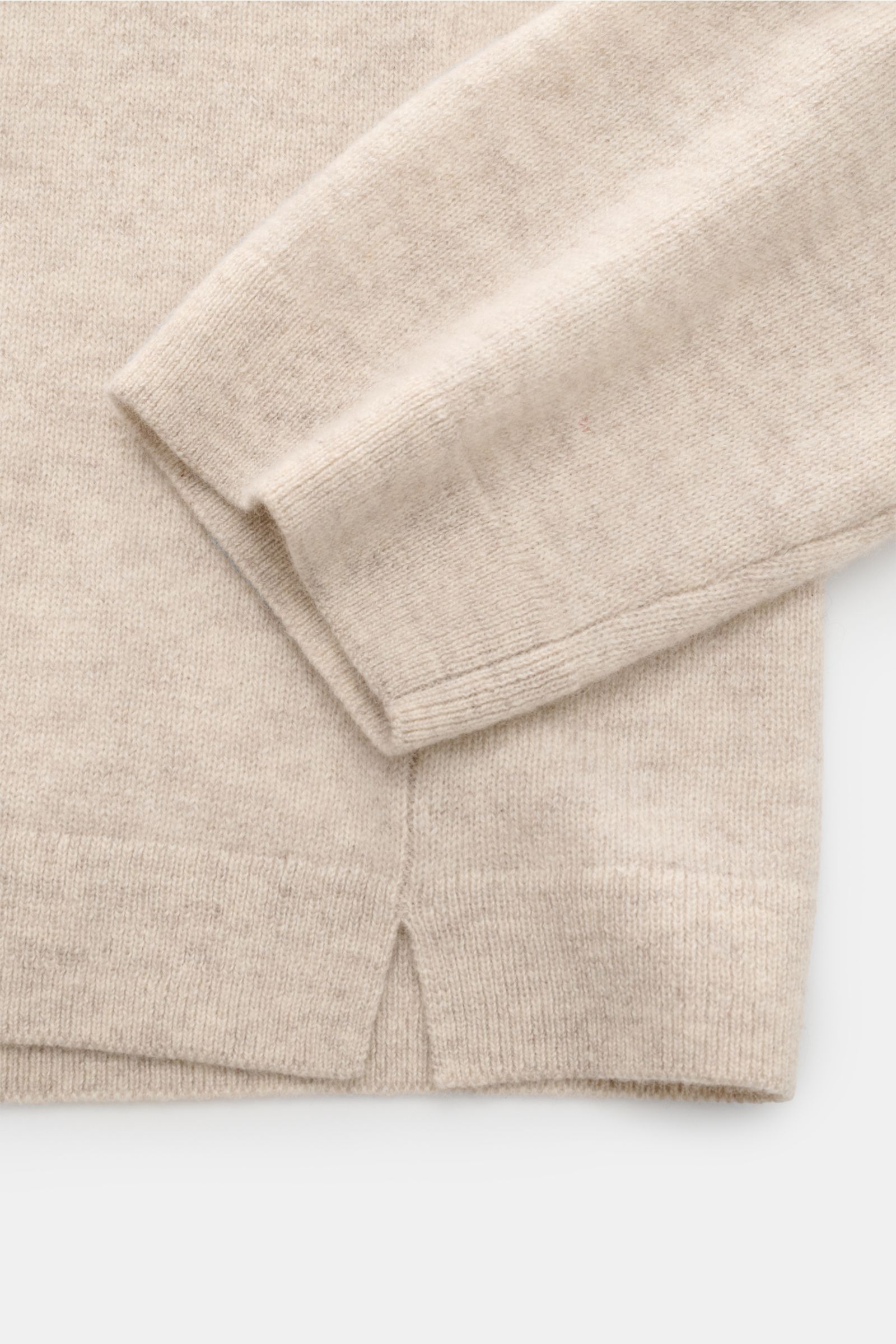 Nahaufnahme des Lisa Yang Cashmere V-Neck-Pullover 'Clayton' sand meliert, Detail von Ärmel und Saum mit kurzen Schlitzen, mittelfeines Strickbild, weicher Griff, Regular Fit, V-Ausschnitt in Rippstrick.