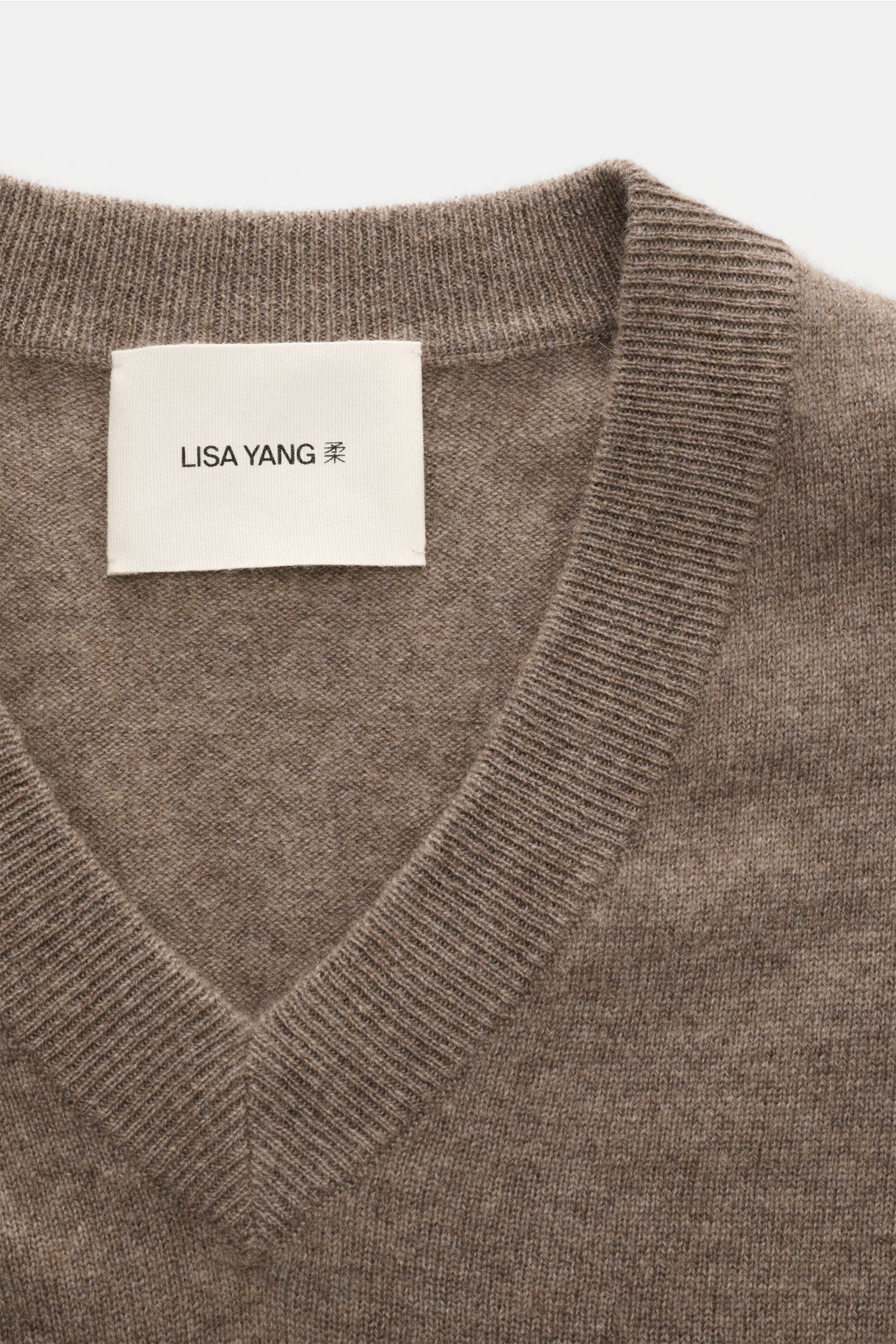 Close-up front-top view of the Lisa Yang Cashmere V-neck jumper 'Clayton' taupe showing the rib knit V-neck and soft medium-fine knit texture.

The Clayton V-neck jumper by LISA YANG combines luxurious cashmere with a modern design in a regular fit and