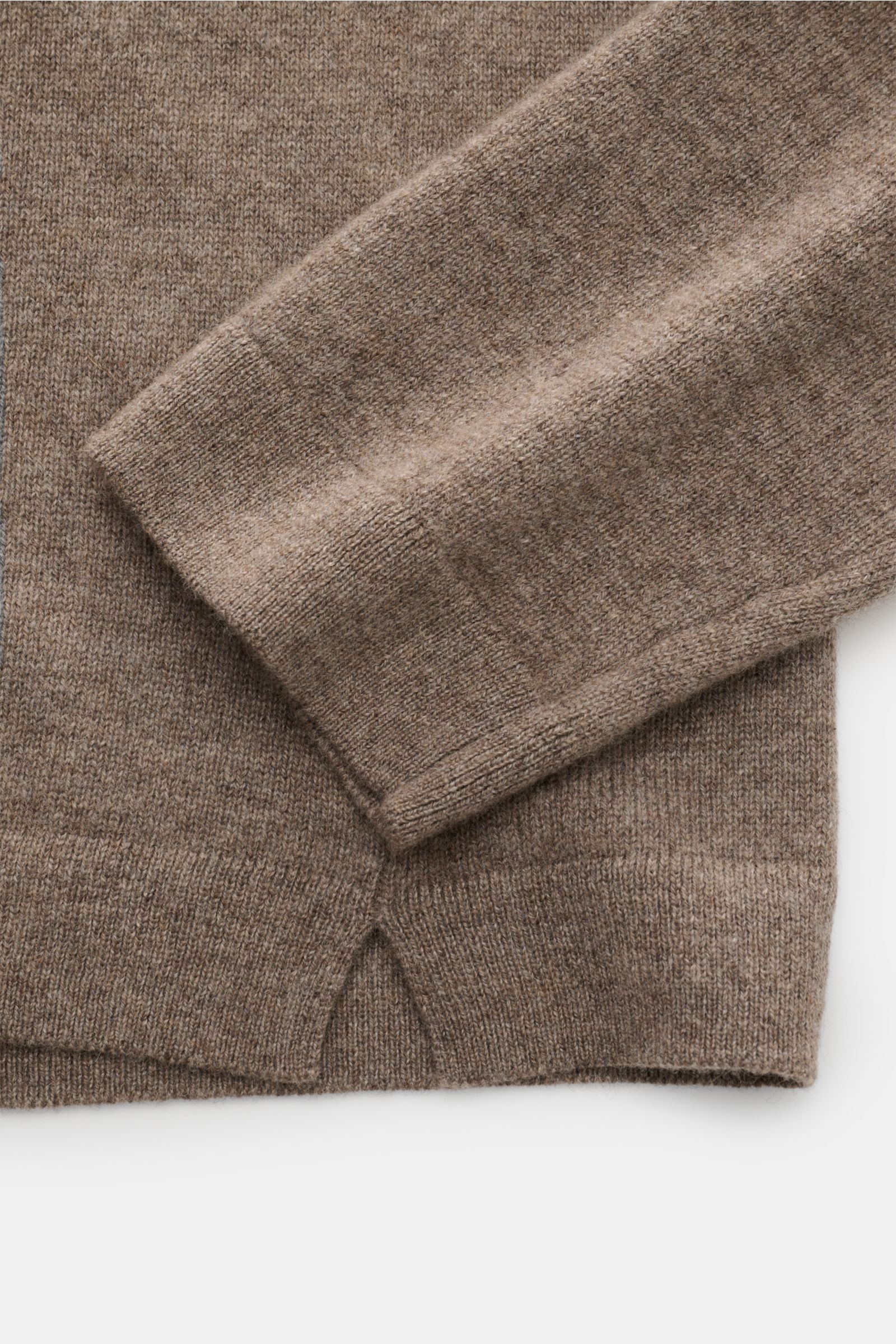 Close-up top-down view of the taupe sleeve and hem of the Lisa Yang Cashmere V-neck jumper 'Clayton' showing medium-fine knit texture and short hem vents.

The Clayton V-neck jumper by LISA YANG combines luxurious cashmere with a modern design in a reg