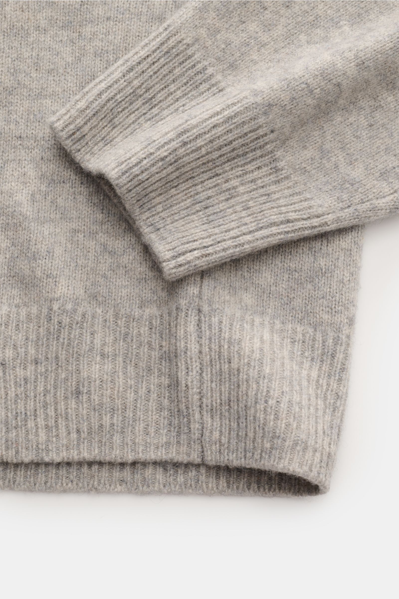 Close-up image from above showing the cuff and hem of the A.P.C. V-Neck Pullover 'Pull Dany' grau meliert made of reine Yak-Wolle, with weicher Griff, mittelfeines Strickbild, Slim Fit, and flexible Rippbündchen.