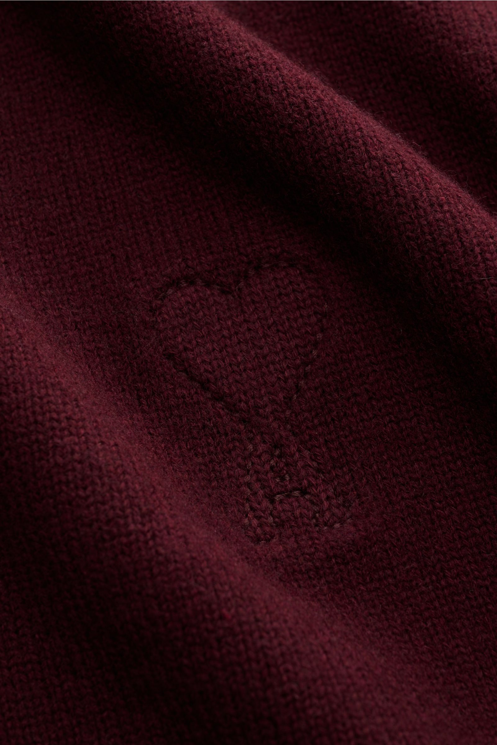 Nahaufnahme des V-Neck Ausschnitts vom Ami Paris V-Neck Pullover bordeaux aus Wolle und Cashmere mit abgestepptem Logo, weichem Strick.