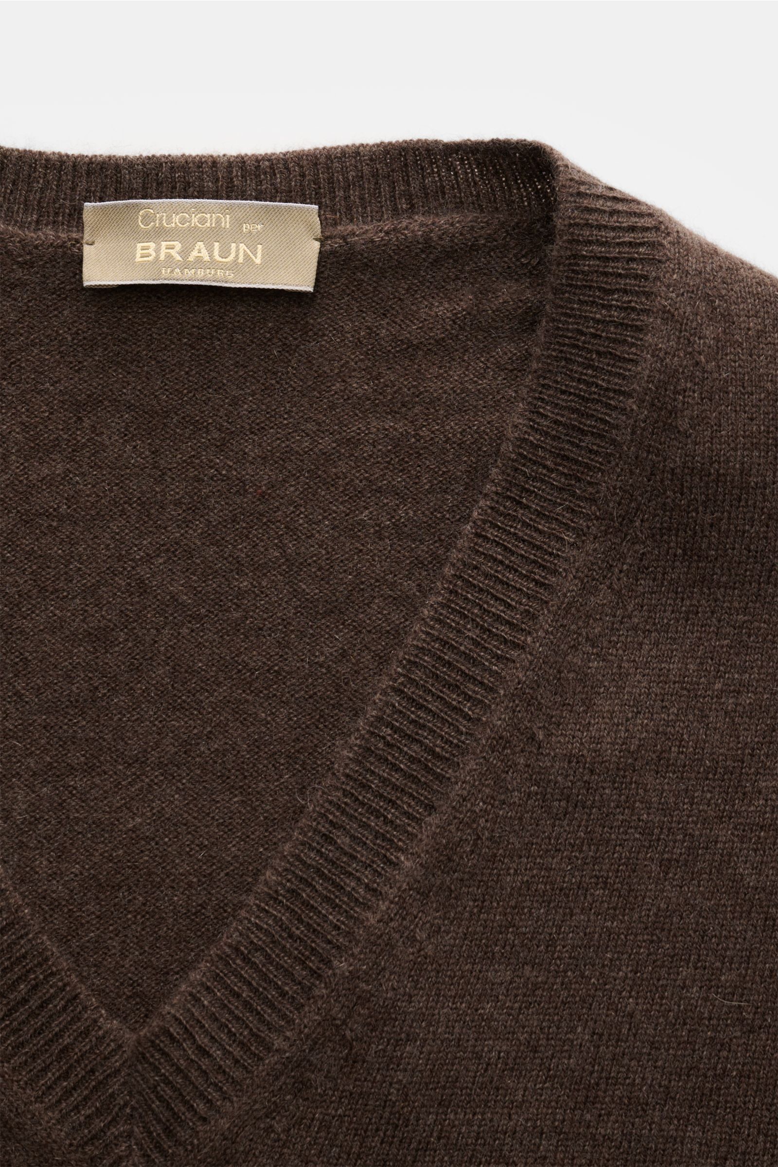 Close-up top view of Cruciani Cashmere V-neck jumper brown showing fine knit, smooth texture, ribbed V-neck and brand label.

Description: This V-neck jumper in pure cashmere by CRUCIANI is the epitome of understatement and style. Its smooth feel and f