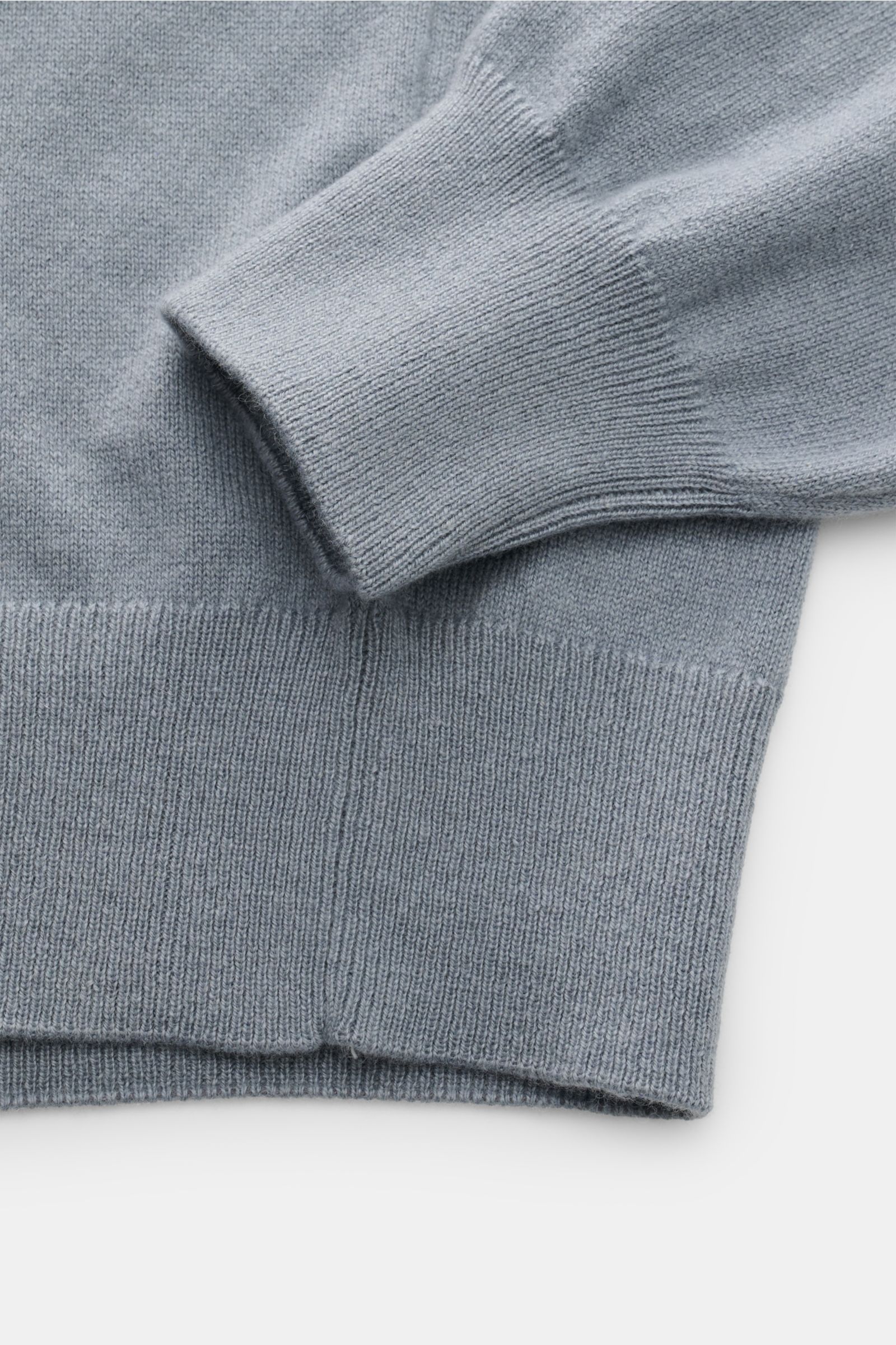 Close-up view of the sleeve and hem of the Cruciani Cashmere V-neck jumper smoky blue, showcasing its fine knit and ribbed bands.

Description: This V-neck jumper in pure cashmere by CRUCIANI is the epitome of understatement and style. Its smooth feel 