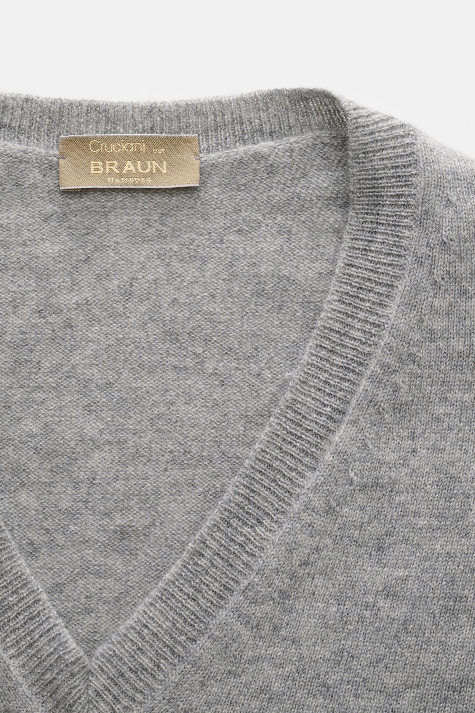 Cruciani Cashmere V-neck jumper grey mottled shown from a close-up top-down view, highlighting the fine knit, V-neck, and ribbed bands. This V-neck jumper in pure cashmere by CRUCIANI is the epitome of understatement and style. Its smooth feel and fine