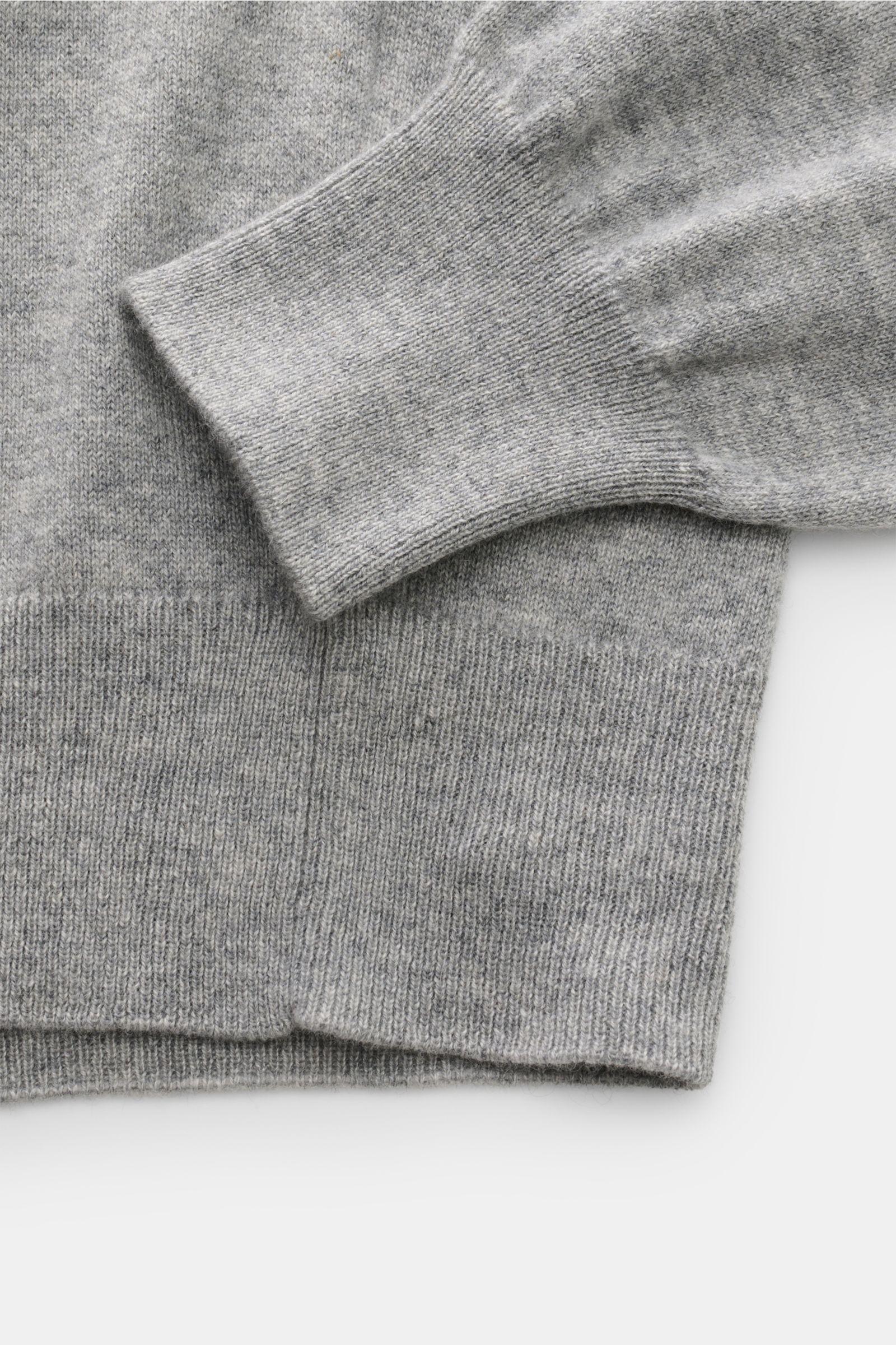 Close-up front view of Cruciani Cashmere V-neck jumper grey mottled's sleeve and ribbed hem, showing fine knit and smooth texture. 

This V-neck jumper in pure cashmere by CRUCIANI is the epitome of understatement and style. Its smooth feel and fine kn