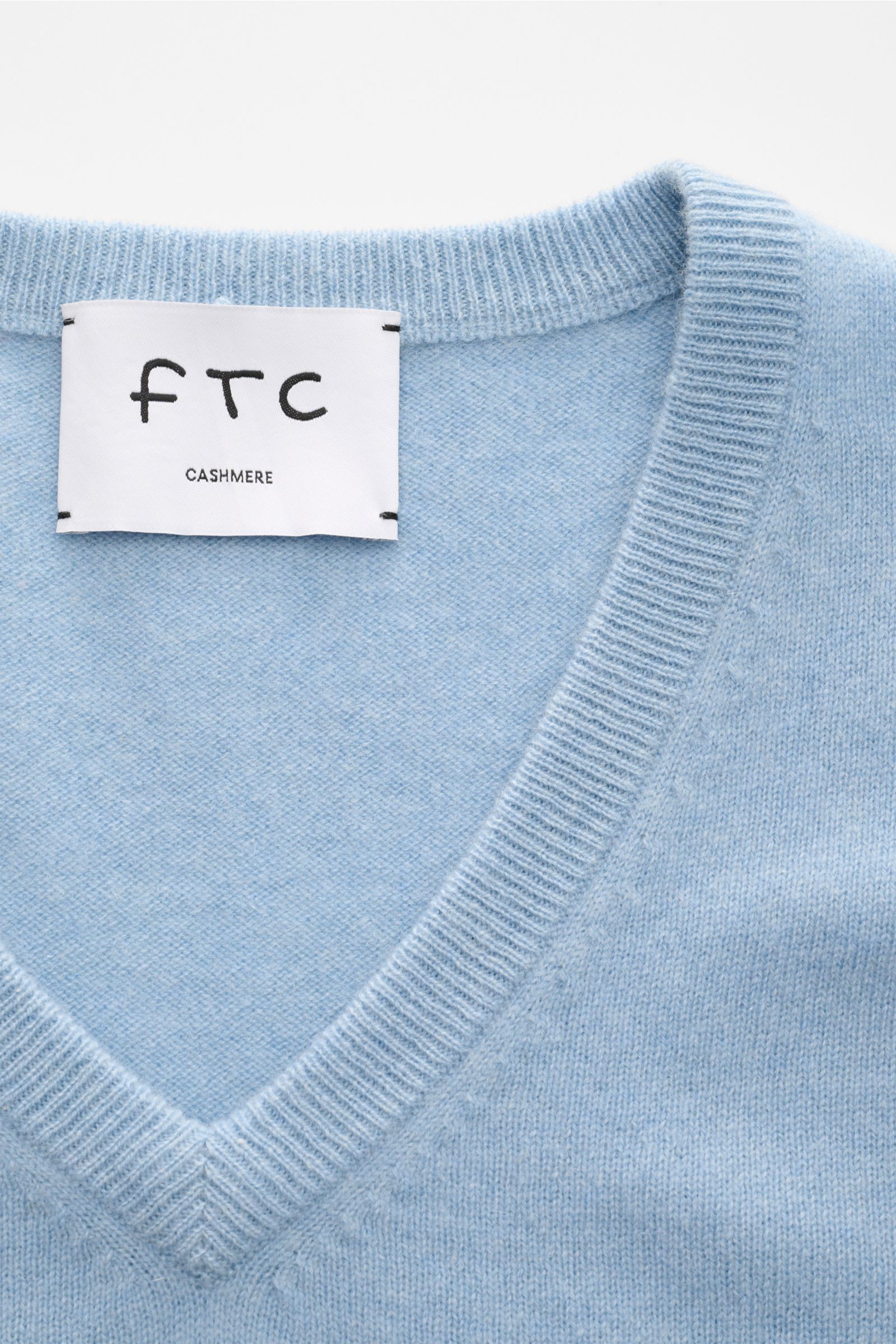 FTC Cashmere V-Neck Pullover hellblau, Nahaufnahme von V-Ausschnitt und Label, Slim Fit, feines Strickbild, weicher Fair-Trade-Cashmere.
