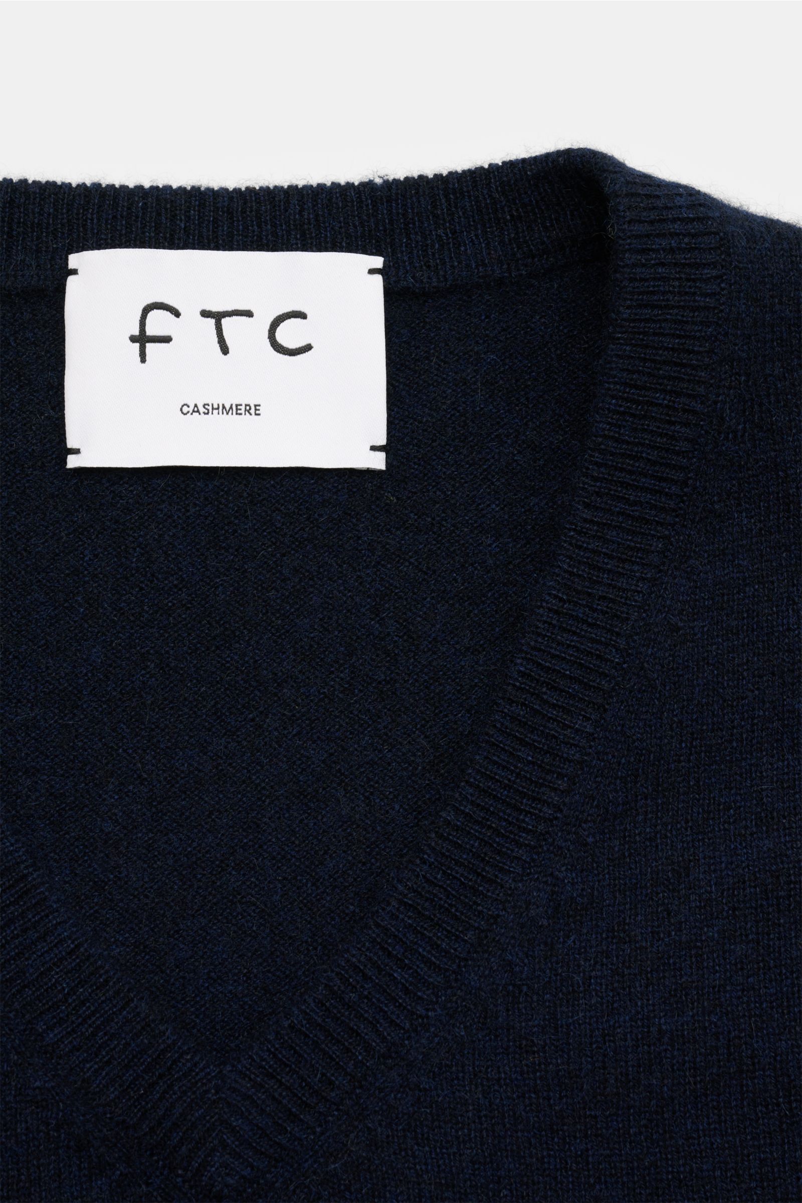FTC Cashmere V-Neck Pullover navy shown from a close-up top-down view highlighting the V-neck and ribbed collar, made of pure fair-trade cashmere.  
Der Pullover mit V-Ausschnitt ist ein Klassiker der Herrenmode, der in keinem Kleiderschrank fehlen dar