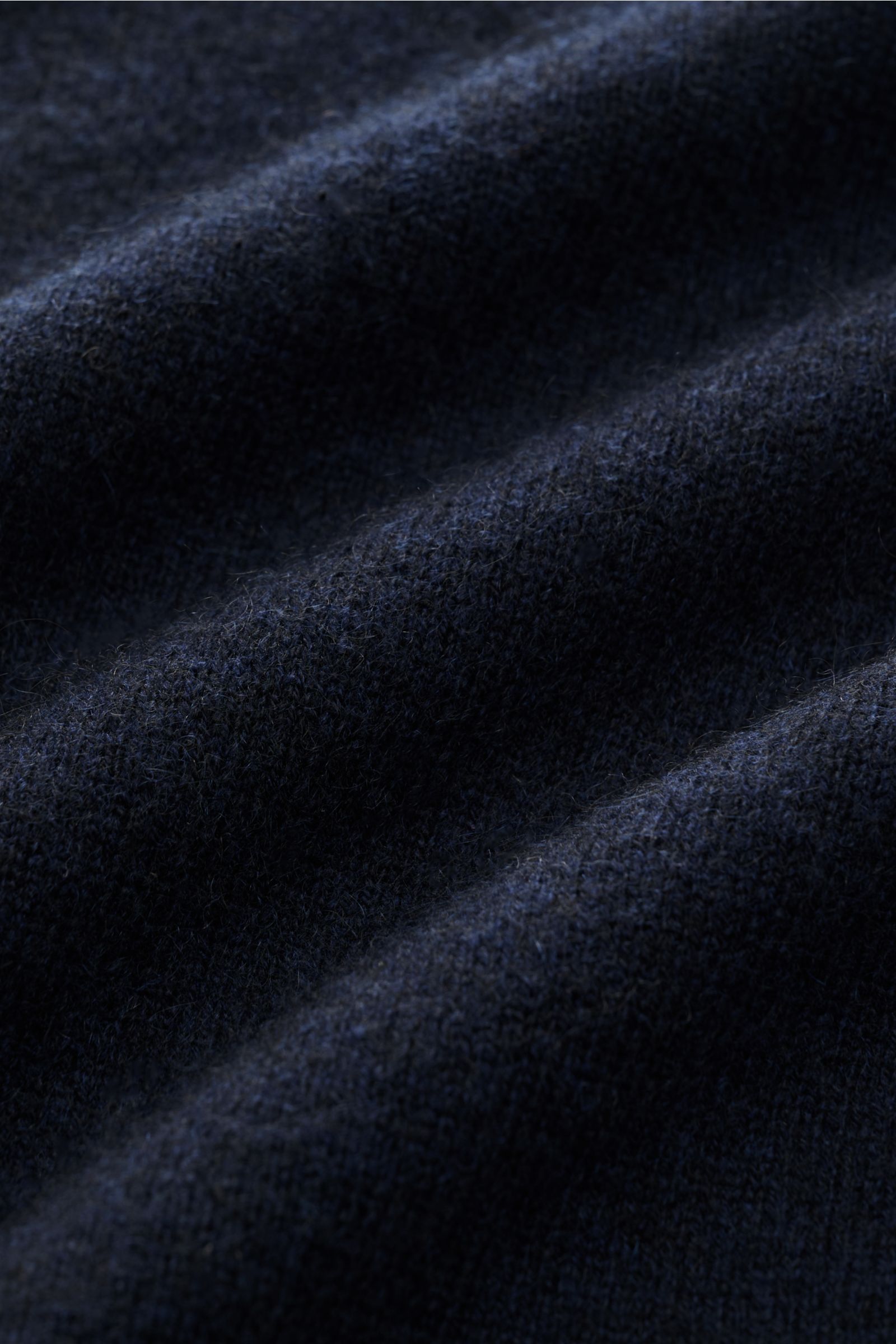 Close-up view of navy fabric texture showing fine knit and soft fibers of the FTC Cashmere V-Neck Pullover navy, made from sustainable Fair-Trade Cashmere with a slim fit, V-neck, and comfortable ribbed cuffs. Der Pullover mit V-Ausschnitt ist ein Klassik
