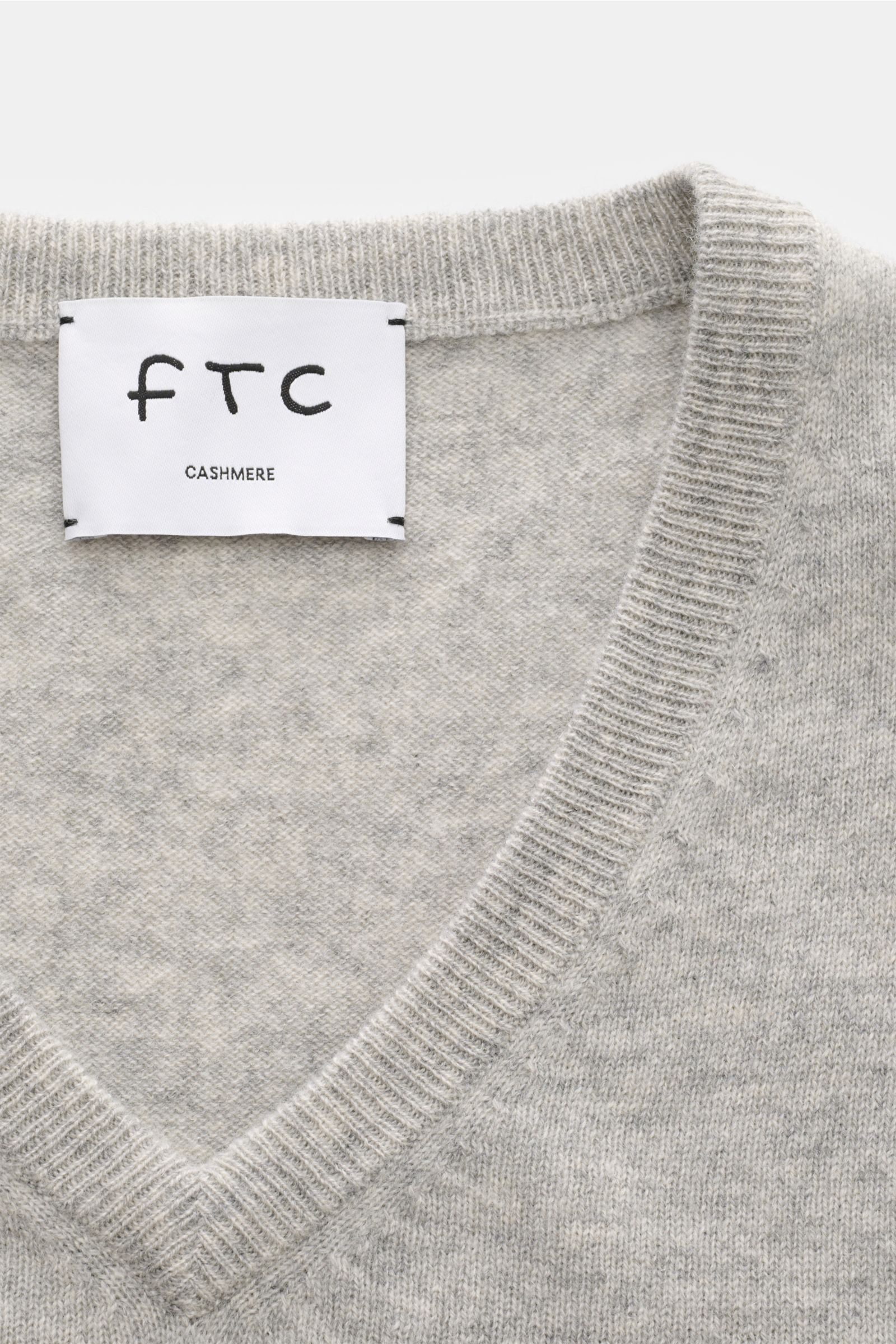 Nahaufnahme des FTC Cashmere V-Neck Pullover grau meliert mit V-Ausschnitt, feinem Strickbild, Rippbündchen, Slim Fit aus nachhaltigem Fair-Trade-Cashmere.