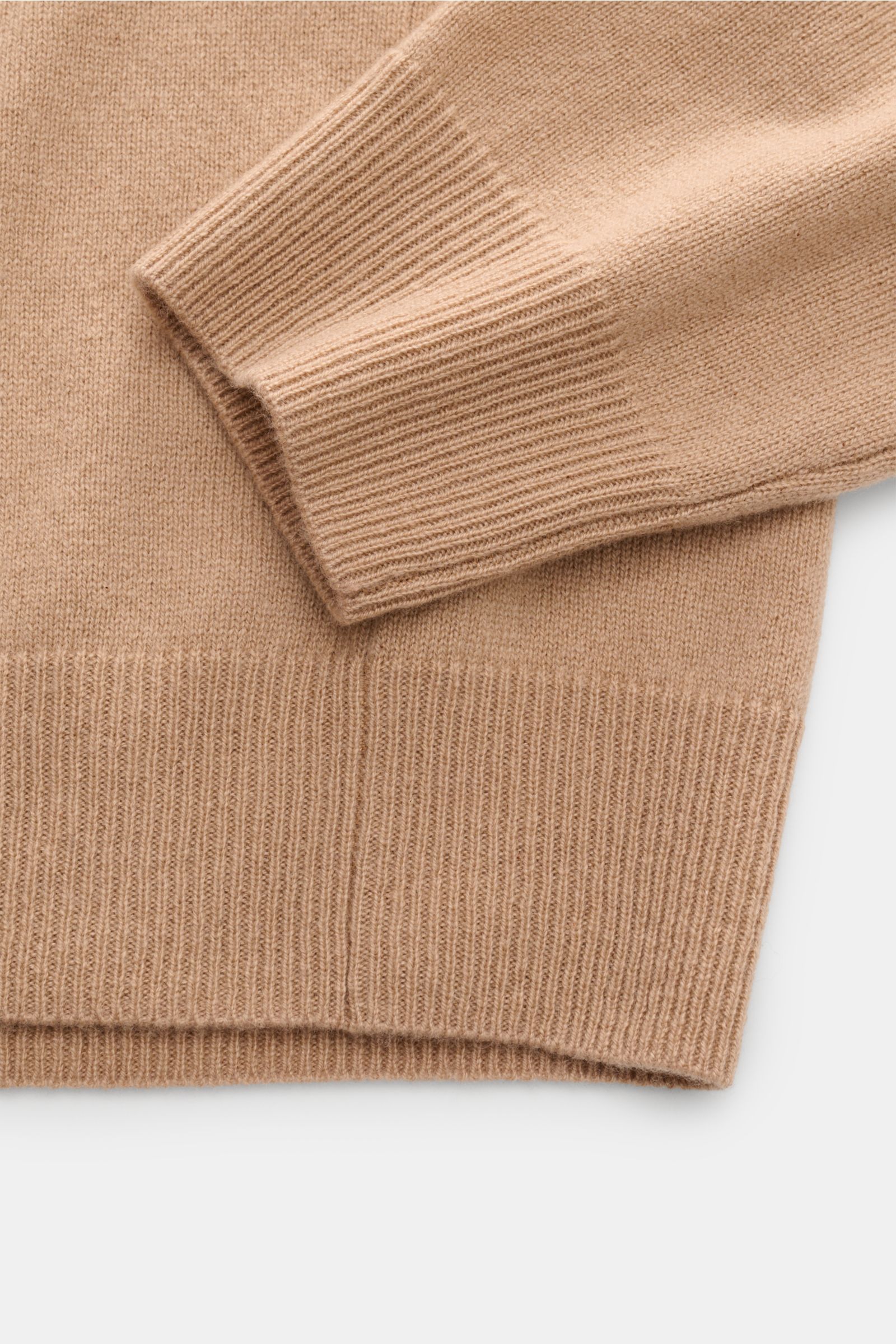 Nahaufnahme des FTC Cashmere V-Neck Pullovers beige, fotografiert von oben, zeigt feines Strickbild, weichen Griff und Rippbündchen.