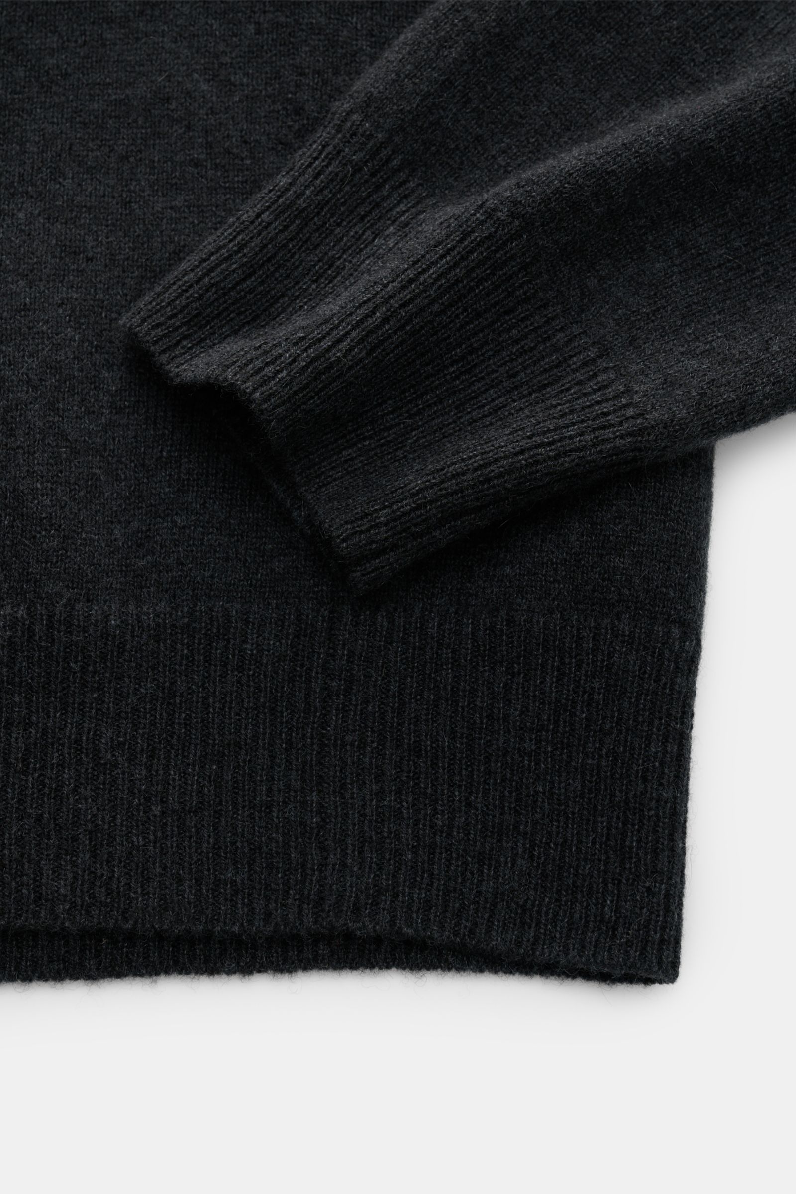 Close-up top-down view of the FTC Cashmere V-Neck Pullover anthrazit sleeve and ribbed hem, made of pure Fair-Trade Cashmere with a soft touch, fine knit, slim fit, V-neck, and comfortable ribbed cuffs. Der Pullover mit V-Ausschnitt ist ein Klassiker d