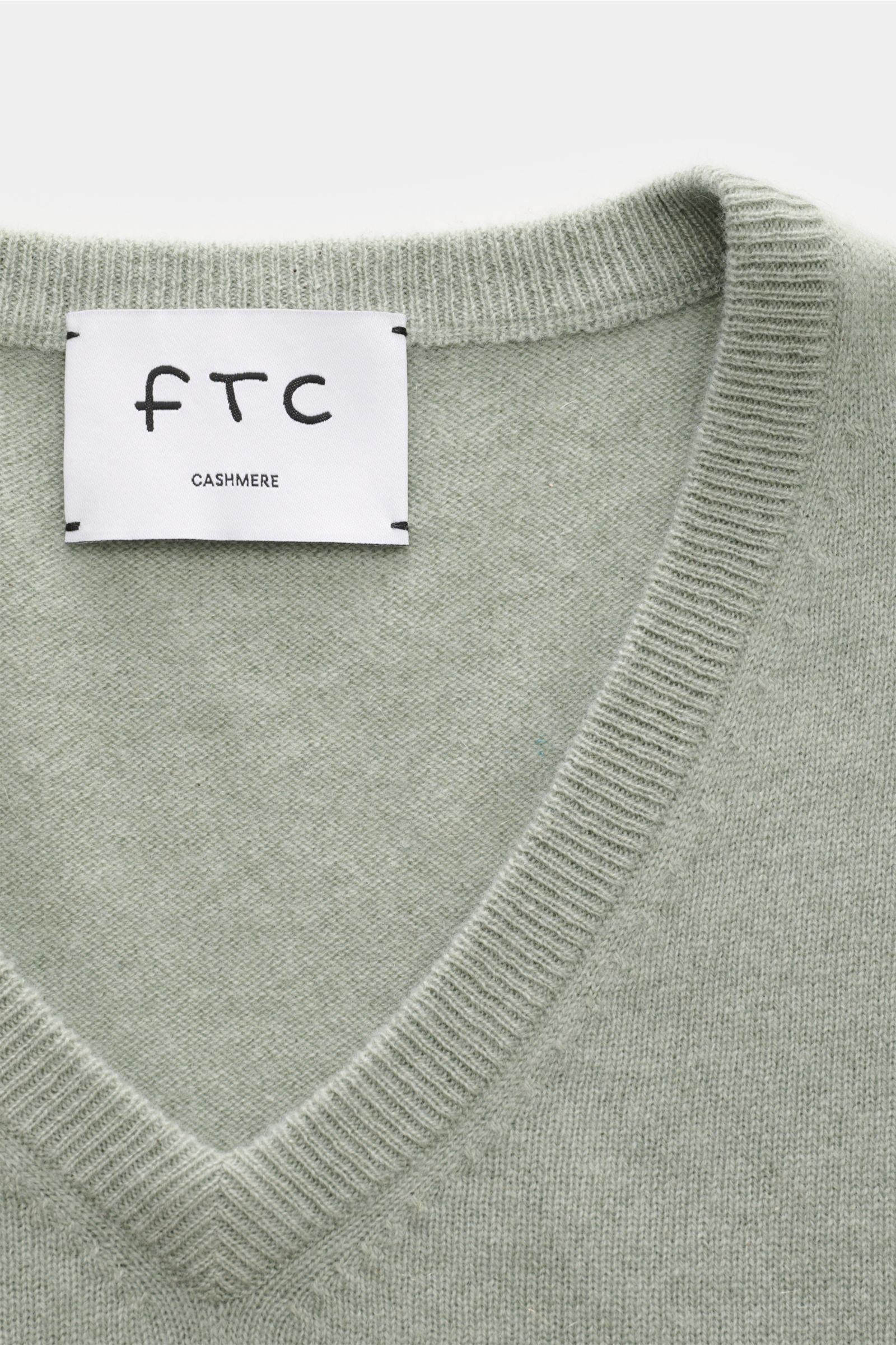 Close-up front view of FTC Cashmere V-Neck Pullover graugrün showing V-neckline with ribbed cuffs and fine knit texture, made from pure Fair-Trade Cashmere.

Der Pullover mit V-Ausschnitt ist ein Klassiker der Herrenmode, der in keinem Kleiderschrank f