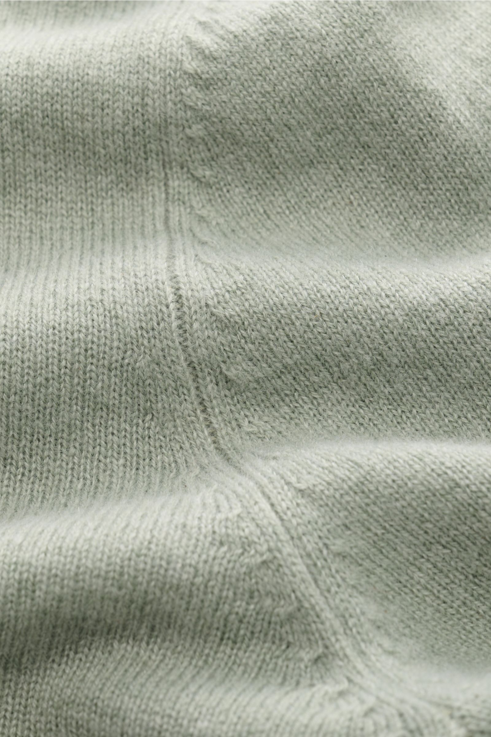 Close-up view of the FTC Cashmere V-Neck Pullover graugrün showing fine knit texture and soft, sustainable Fair-Trade cashmere.

Description: Der Pullover mit V-Ausschnitt ist ein Klassiker der Herrenmode, der in keinem Kleiderschrank fehlen darf – aus
