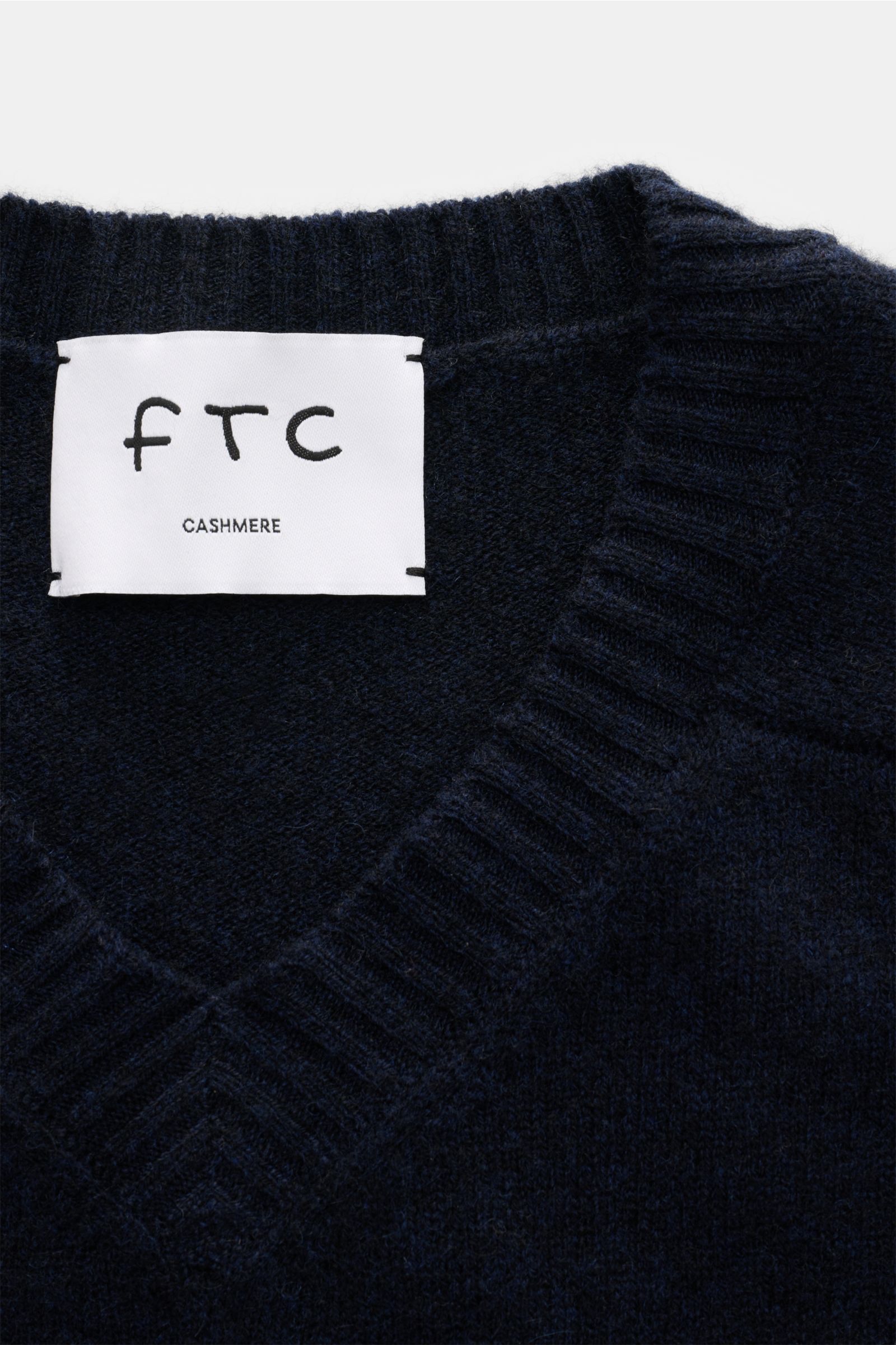 Nahaufnahme des FTC Cashmere V-Neck-Pullover navy mit V-Ausschnitt, mittelfeinem Strickbild, Rippbündchen, Fair-Trade-Cashmere, OEKO-TEX®, hohem Stretch und weichem Griff.