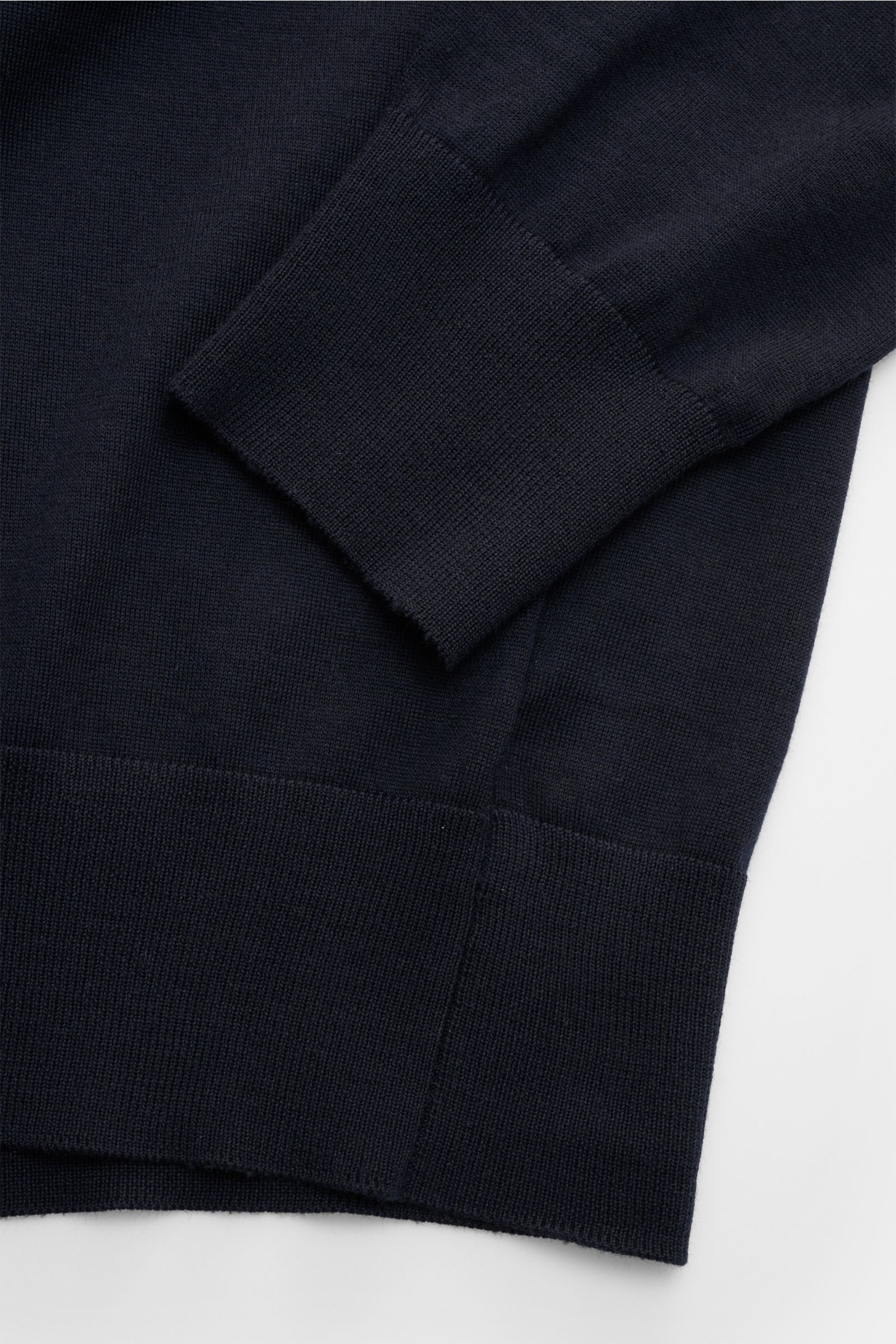 Agnona Rundhalspullover dark navy aus reiner Wolle, Slim Fit, feines Strickbild, Rundhalsausschnitt, Rippbündchen, Detail von Ärmel und Saum, flach fotografiert.