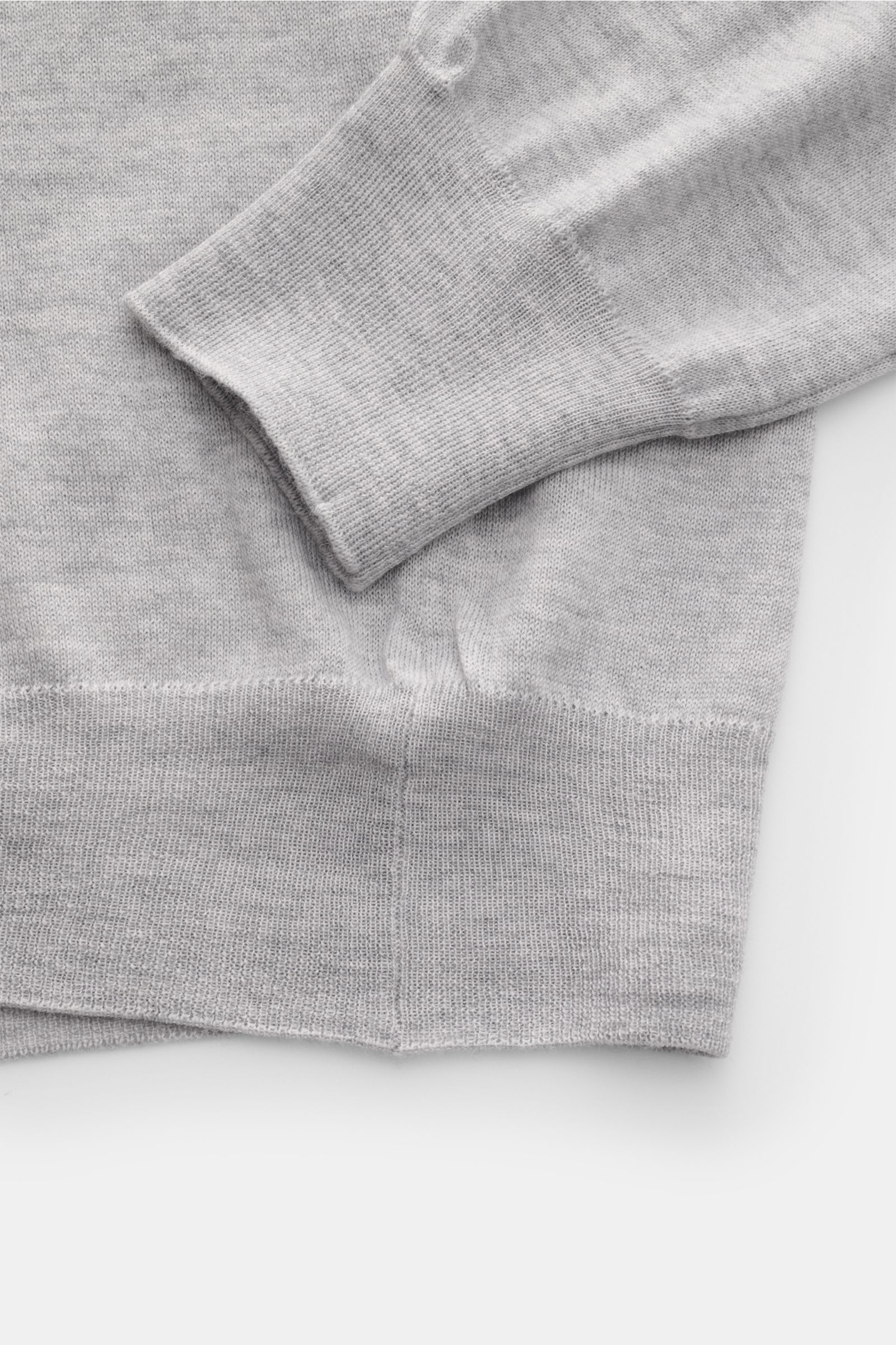 Gran Sasso V-Neck Pullover grau meliert shown from a close-up top-down view, highlighting cuff and hem ribbing, fine wool knit texture. Feiner Zwirn von GRAN SASSO: Oder zumindest feiner Strick - denn dieser V-Neck Pullover aus reiner Wolle ist federleich