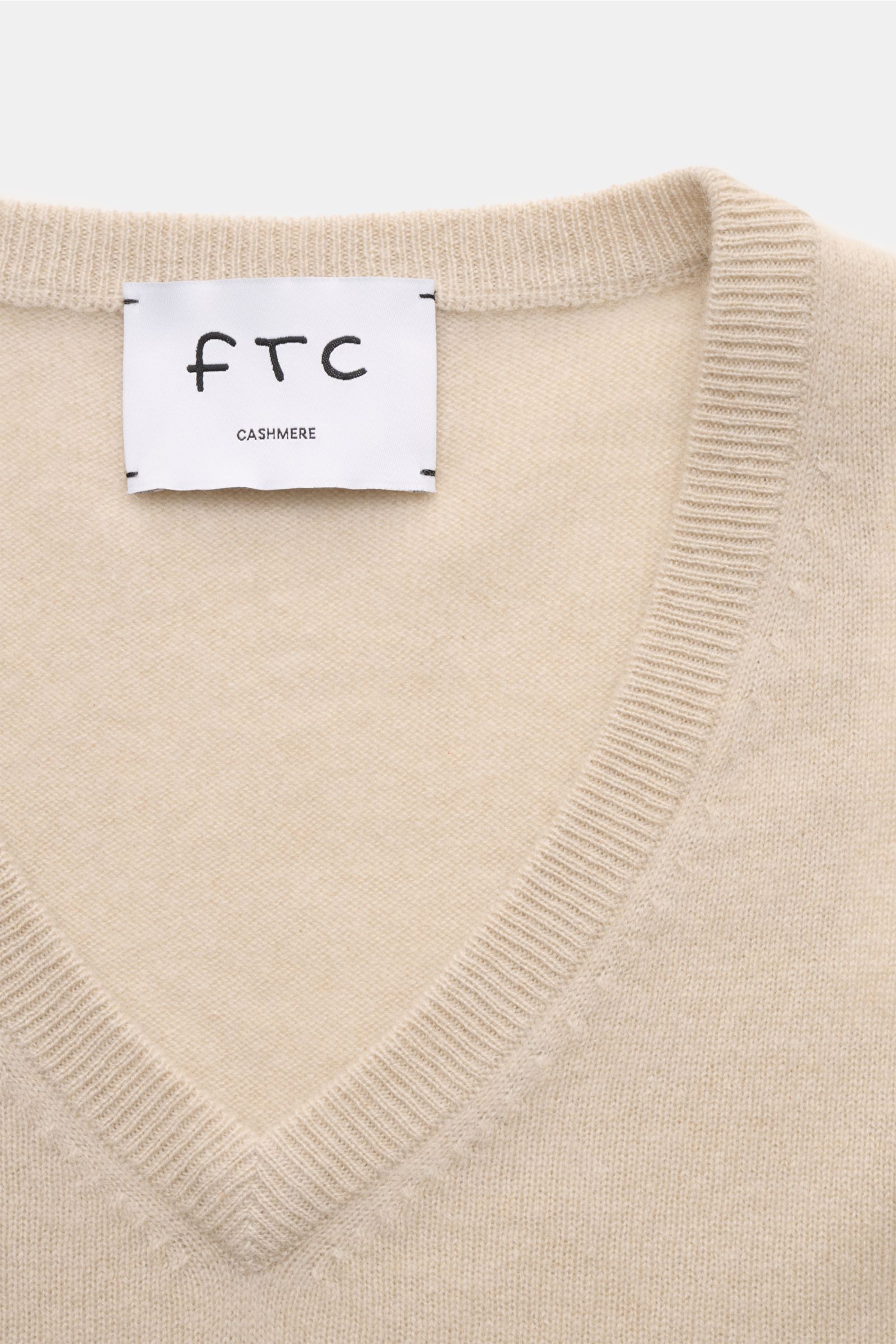 Nahaufnahme des FTC Cashmere V-Neck Pullovers beige, nachhaltig aus Fair-Trade-Cashmere, Slim Fit mit V-Ausschnitt und Rippbündchen.