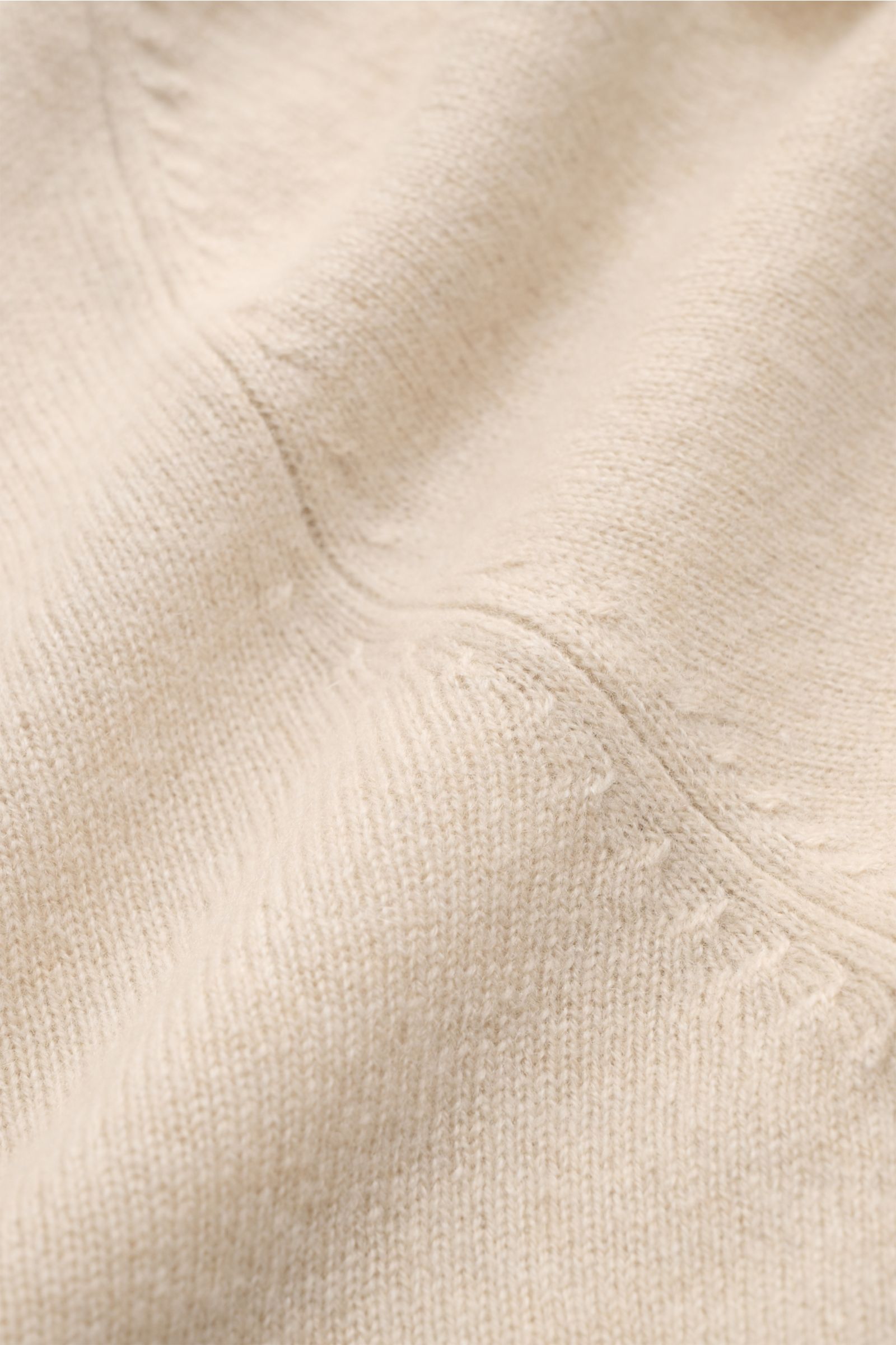 Nahaufnahme des beigen FTC Cashmere V-Neck Pullovers mit feinem Strickbild, nachhaltigem Fair-Trade-Cashmere, Slim Fit und komfortablen Rippbündchen.