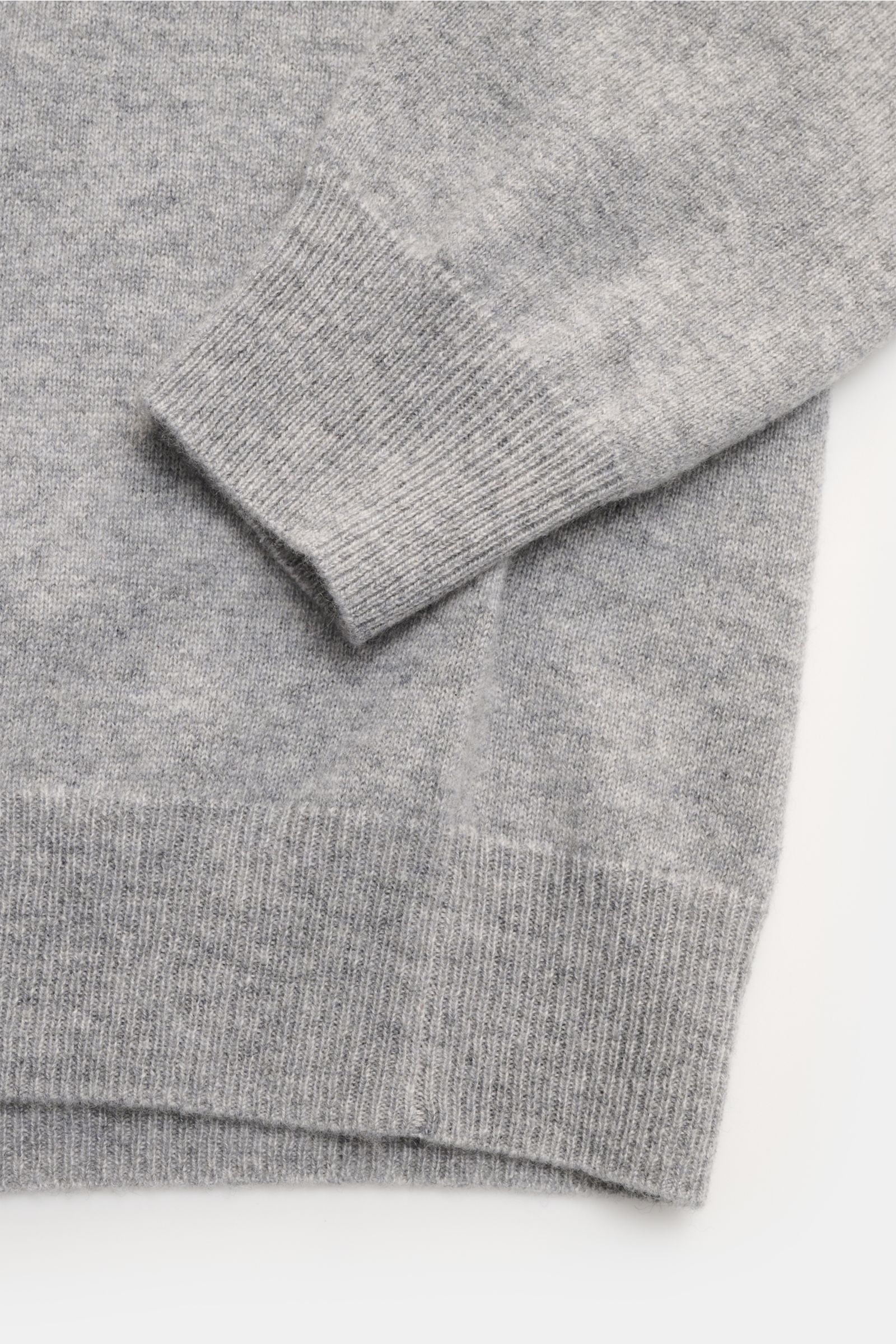 Nahaufnahme von Ärmel und Bund des FTC Cashmere V-Neck Pullovers grau, nachhaltig aus reinem Fair-Trade-Cashmere, fein gestrickt, Slim Fit, mit komfortablen Rippbündchen.