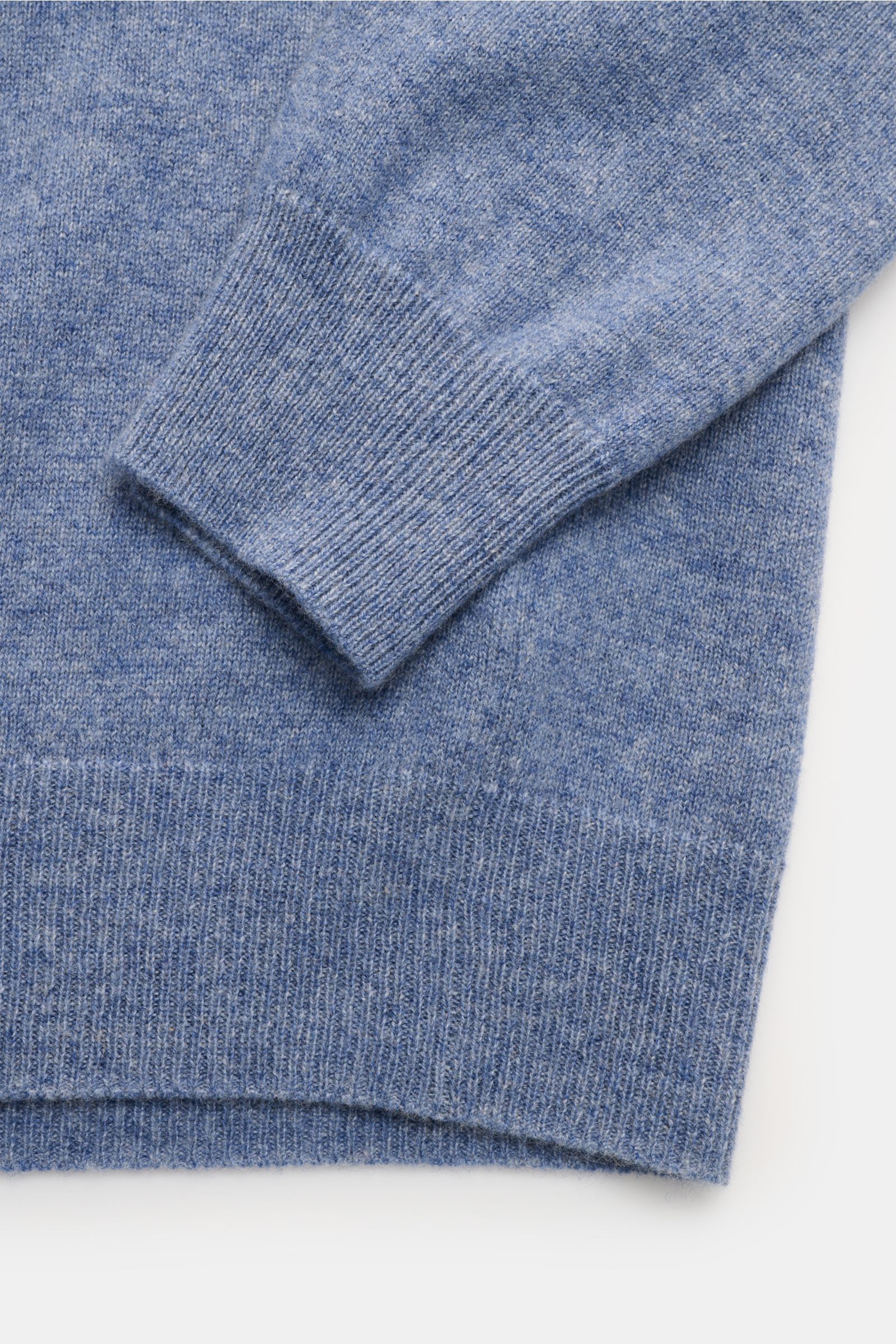 Nahaufnahme des FTC Cashmere V-Neck Pullovers rauchblau meliert von oben, zeigt feines Strickbild, Slim Fit, V-Ausschnitt, weiche Fair-Trade-Cashmere-Faser und komfortable Rippbündchen, nachhaltig produziert.