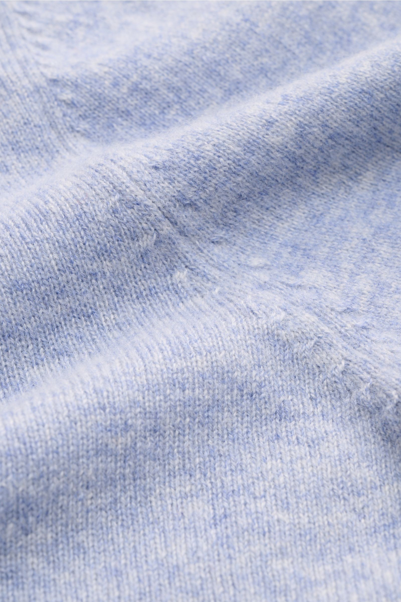 Nahaufnahme des fein gestrickten, hellblau melierten FTC Cashmere V-Neck Pullovers mit weichem Griff, Slim Fit und Rippbündchen.