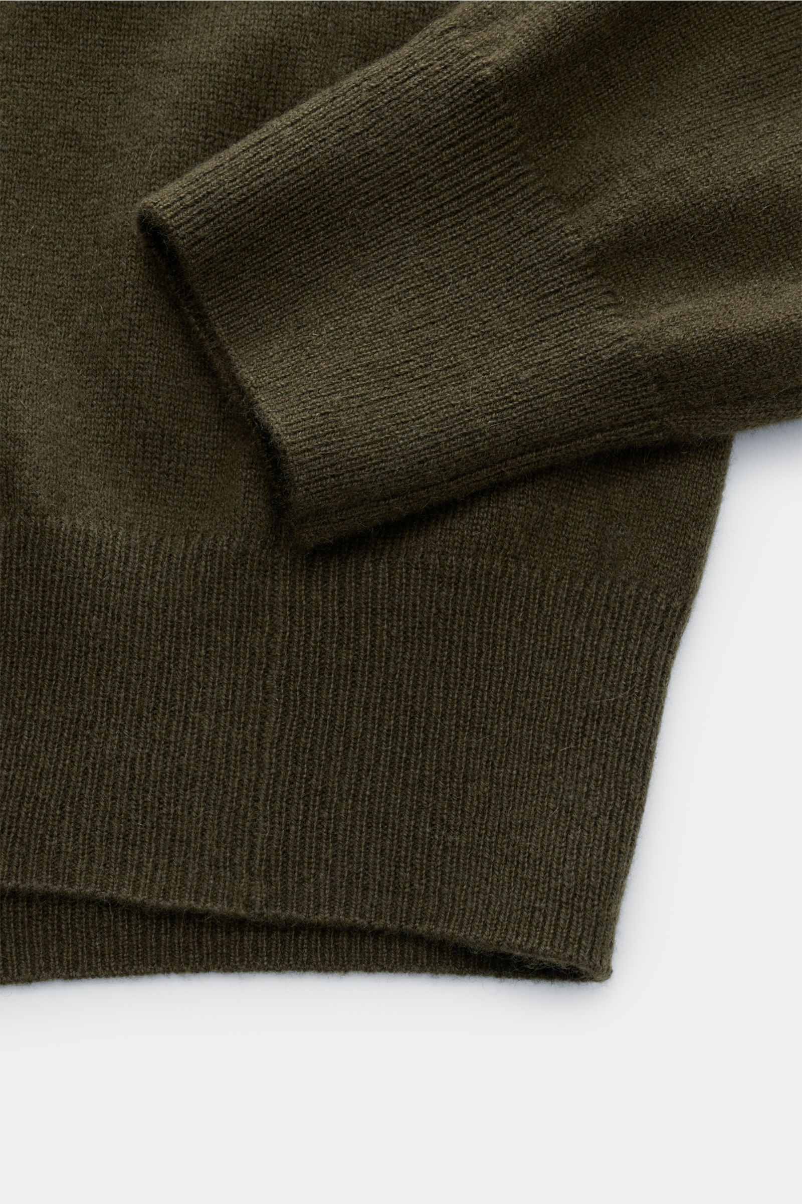 Close-up top-down view of the sleeve and hem of the von Braun Cashmere V-Neck Pullover dark olive, showing fine knit texture and ribbed cuffs.  
Geschmeidiges Basic für die kalte Jahreszeit: Der VON BRAUN V-Neck Pullover – gefertigt aus reinem Cashmer