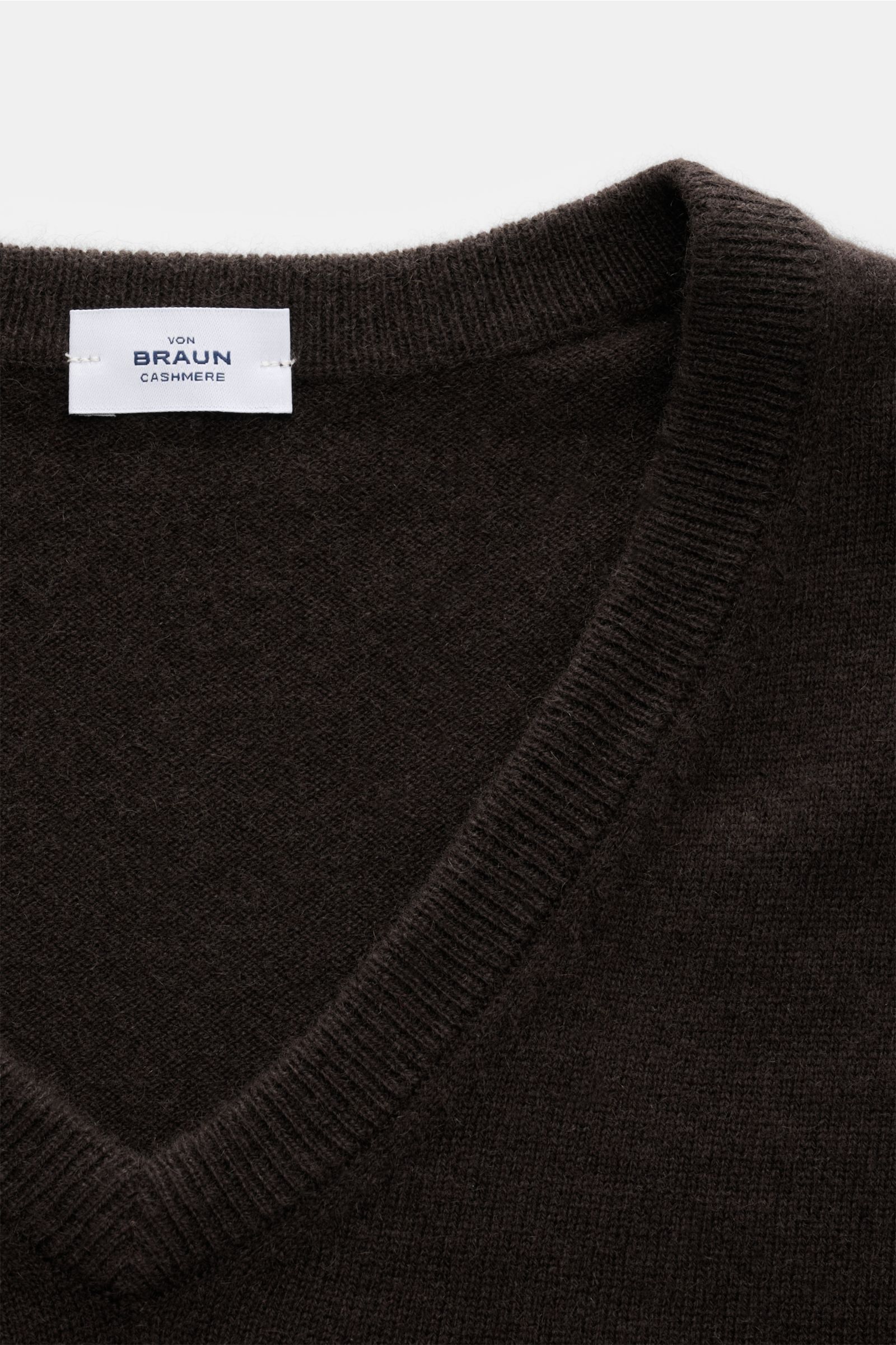 Nahaufnahme des von Braun Cashmere V-Neck Pullovers dunkelbraun mit V-Ausschnitt, feinem Strickbild, elastischen Rippbündchen, Slim Fit und weichem Griff aus reinem Cashmere.