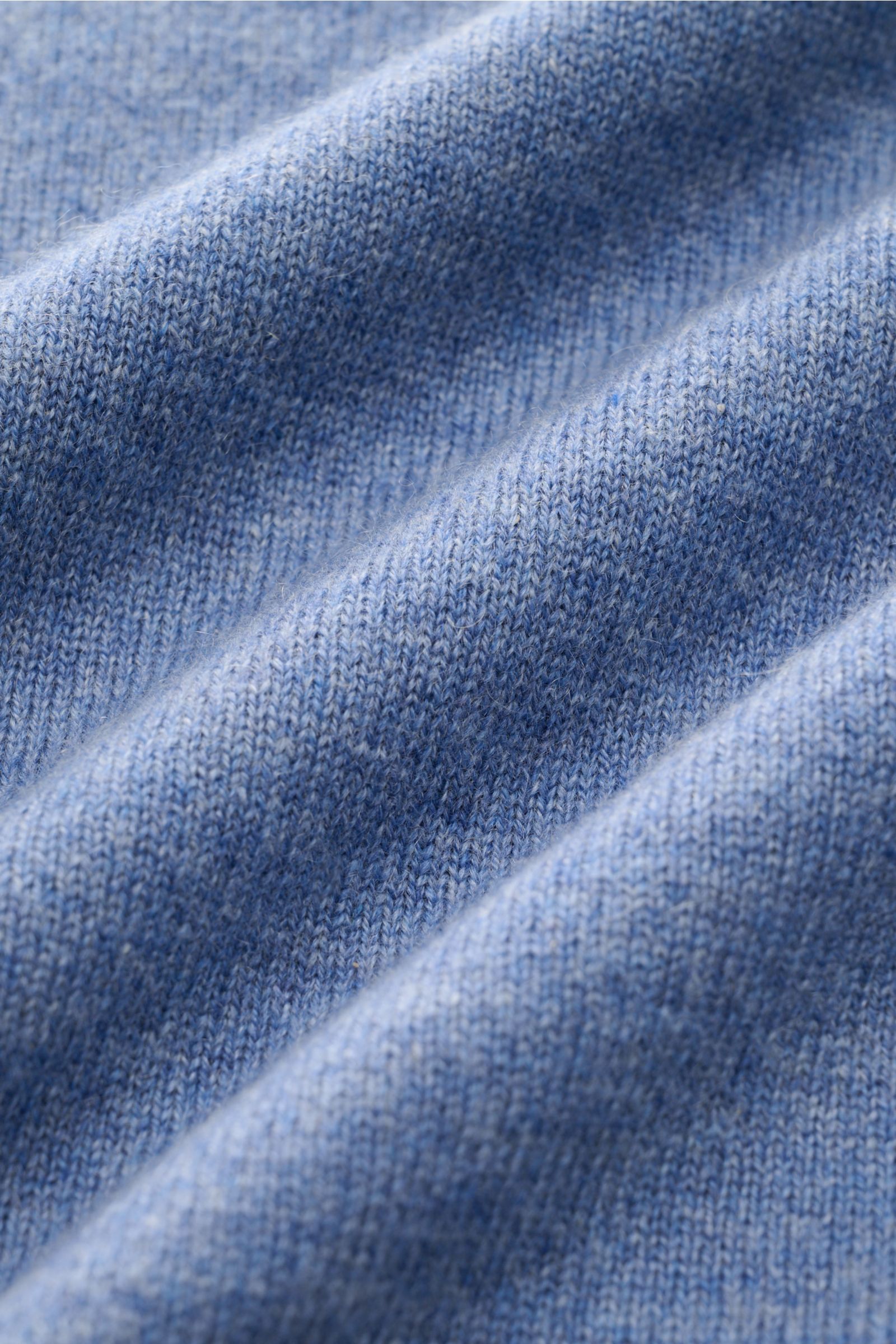 Nahaufnahme des feinen Strickbilds des von Braun Cashmere V-Neck Pullovers blau meliert, gefertigt aus reinem, weichem Cashmere mit elastischen Rippbündchen.