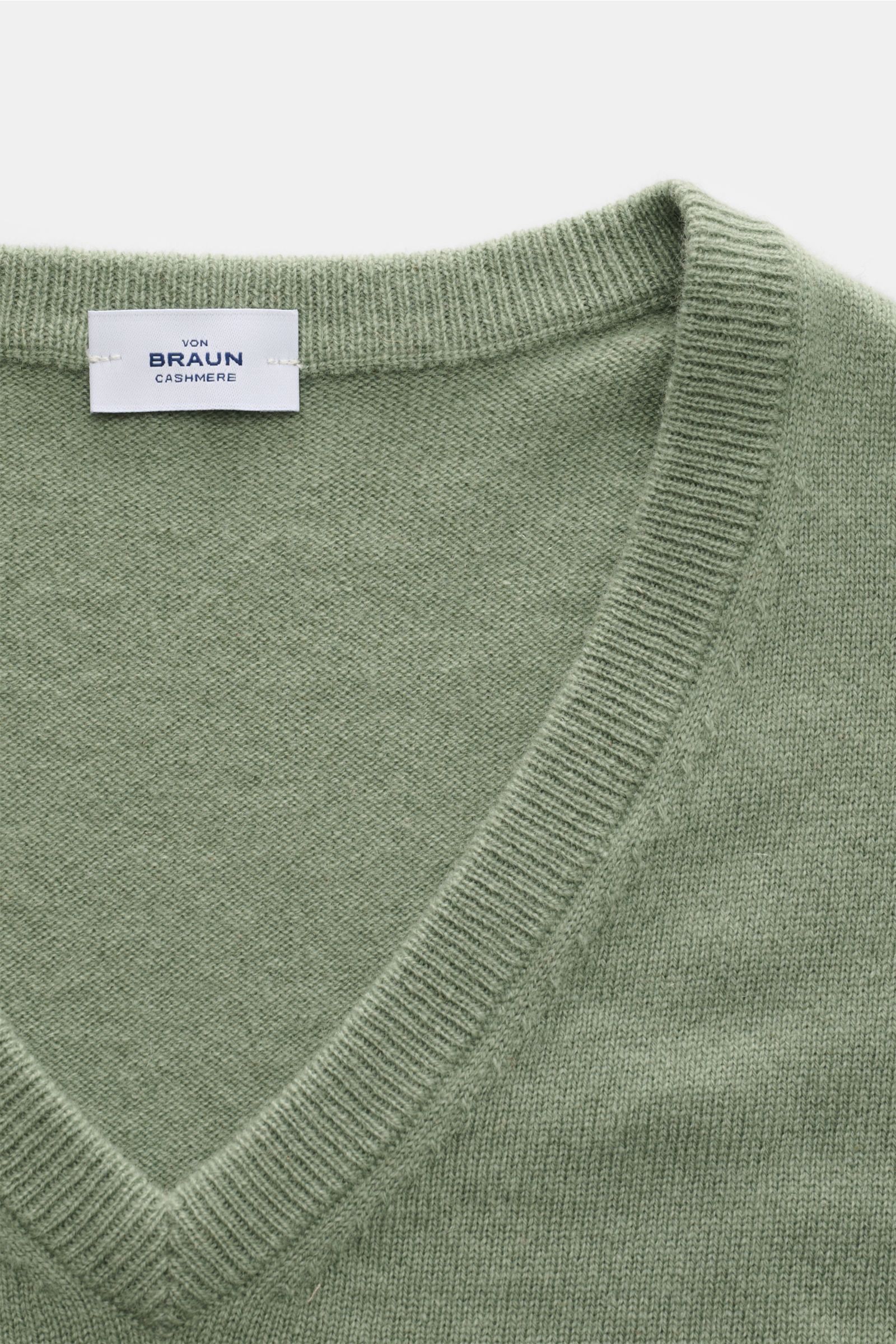 Nahaufnahme des von Braun Cashmere V-Neck Pullovers graugrün mit feinem Strickbild, V-Ausschnitt und elastischen Rippbündchen, gefertigt aus reinem Cashmere.