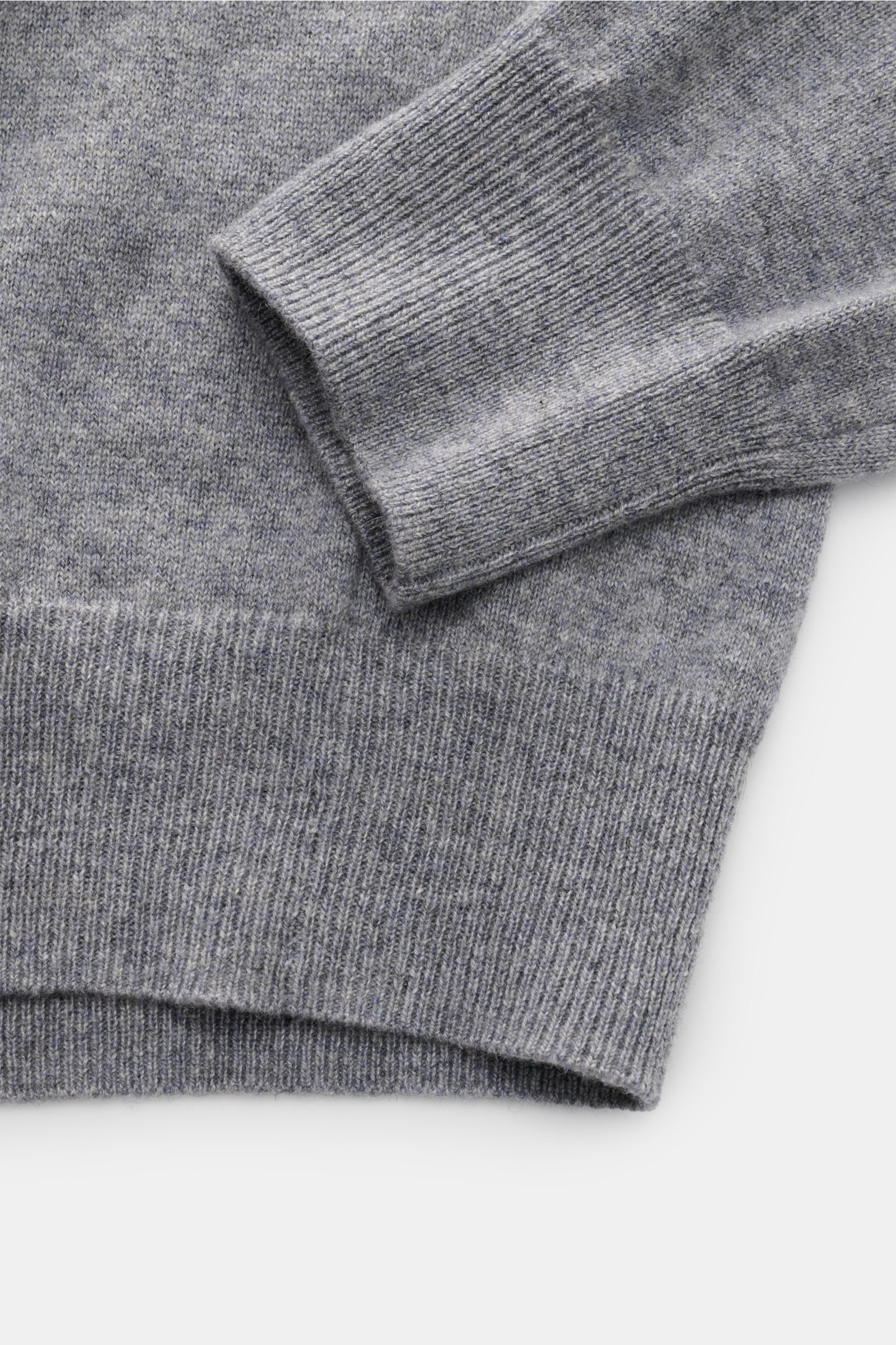 Nahaufnahme des von Braun Cashmere V-Neck Pullovers grau meliert von schräg oben, zeigt feines Strickbild, elastische Rippbündchen, Slim Fit, sehr weicher Griff, reiner Cashmere.