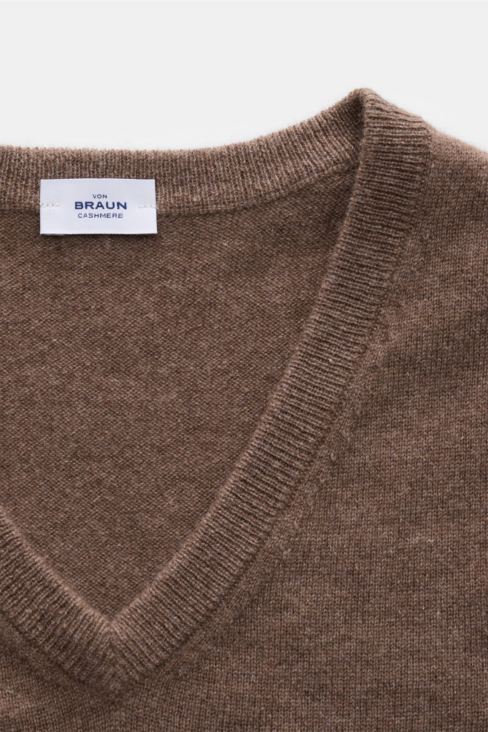 Nahaufnahme von von Braun Cashmere V-Neck Pullover graubraun meliert mit feinem Strickbild, V-Ausschnitt und elastischen Rippbündchen.