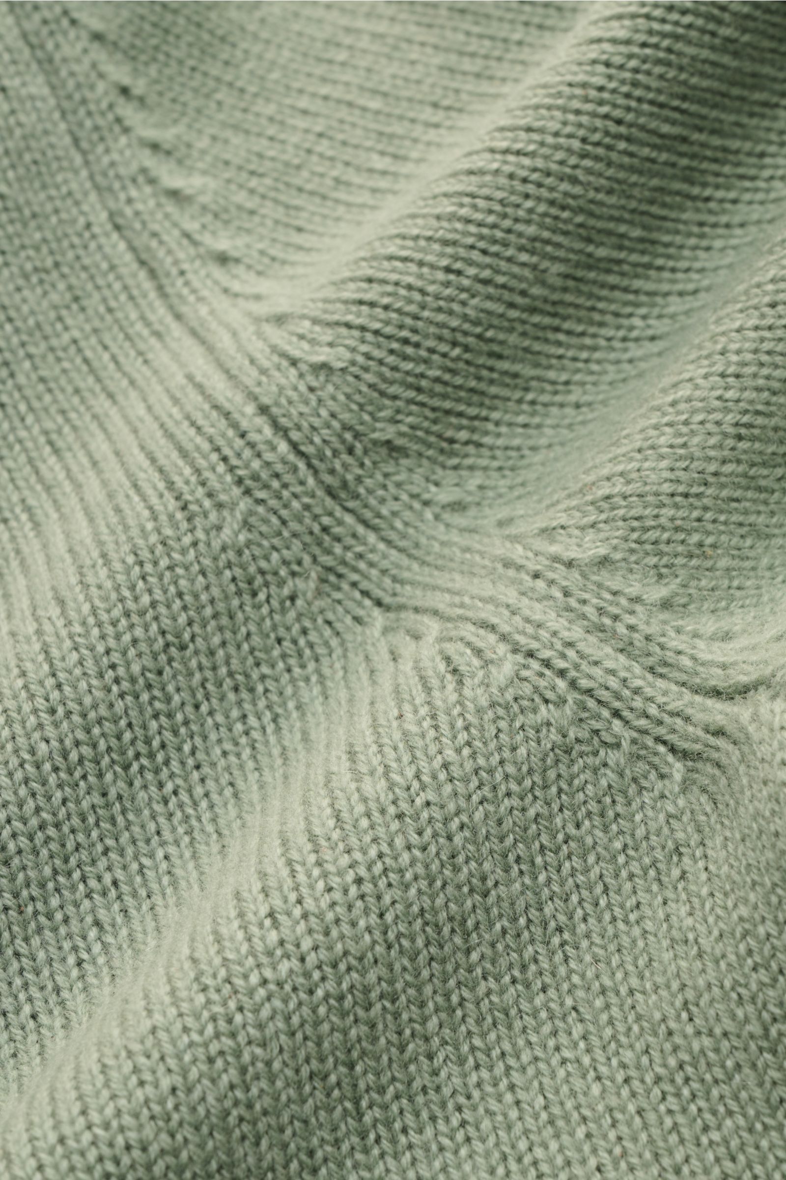 Nahaufnahme des von Braun Cashmere V-Neck Pullover salbei, zeigt mittelfeines Strickbild und weichen Griff aus reiner mongolischer Wolle.