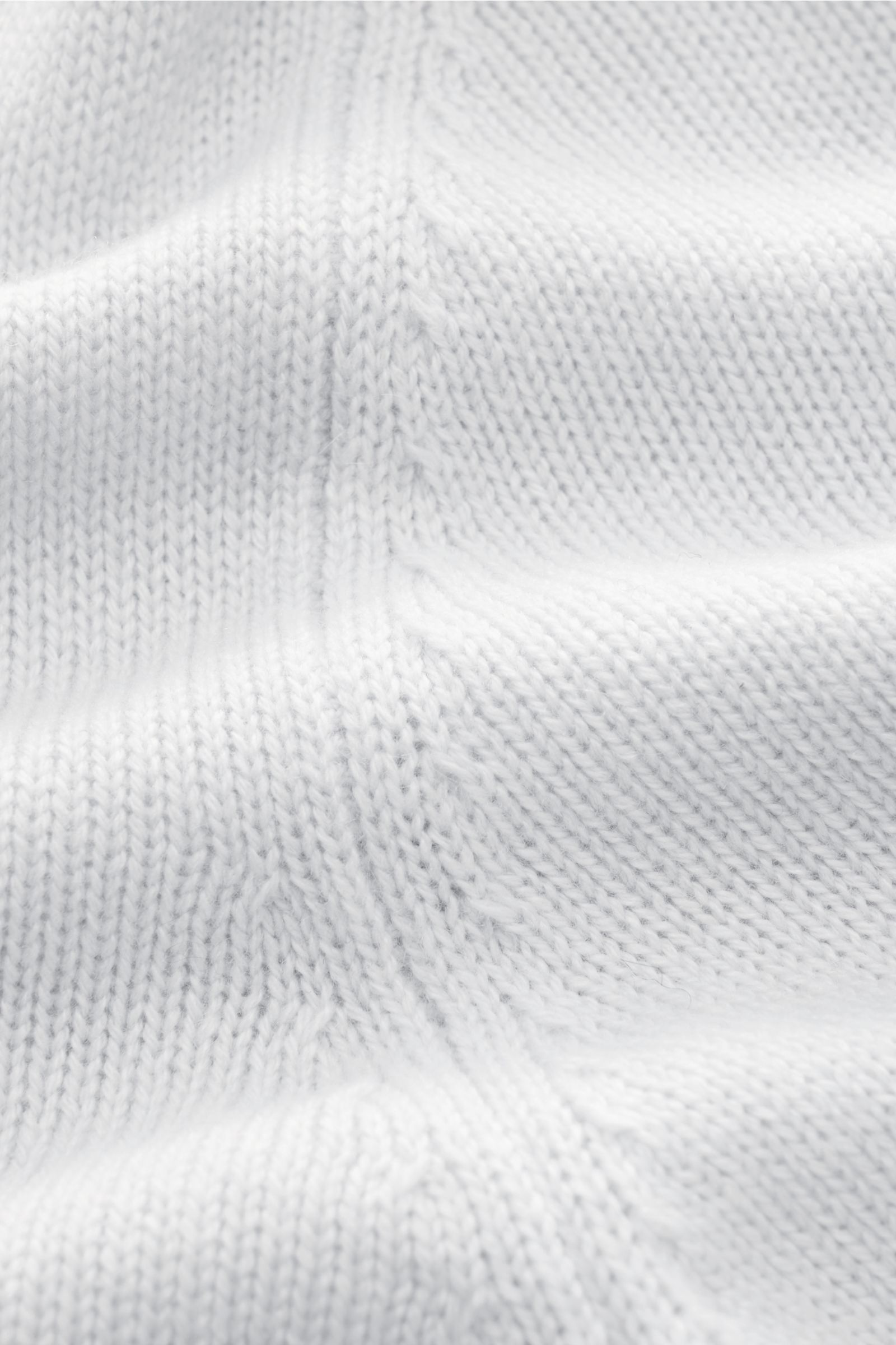 Nahaufnahme des mittelfeinen Strickbilds eines hellgrauen von Braun Cashmere V-Neck Pullovers aus reinem mongolischem Cashmere mit weichem Griff.