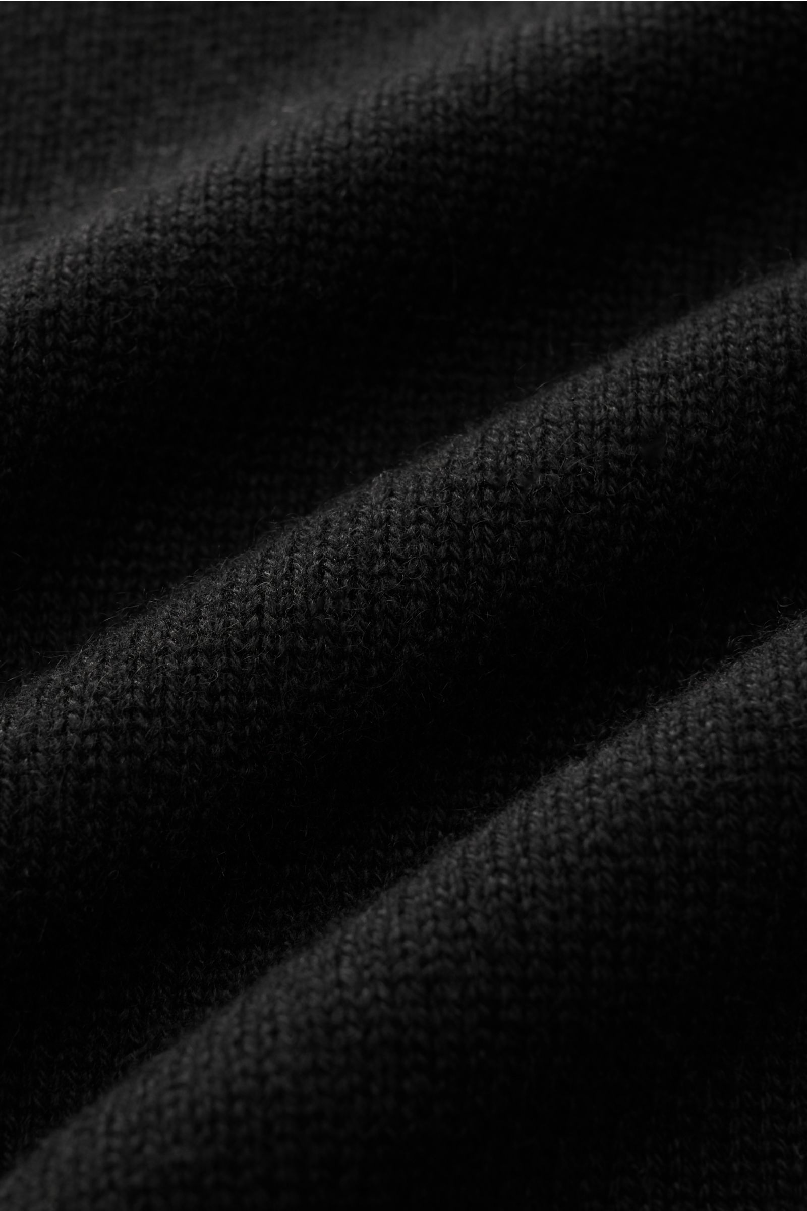 Schwarzes Detailbild des von Braun Cashmere V-Neck Pullovers mit mittelfeinem Strickbild, weichem Griff und elastischen Rippbündchen.