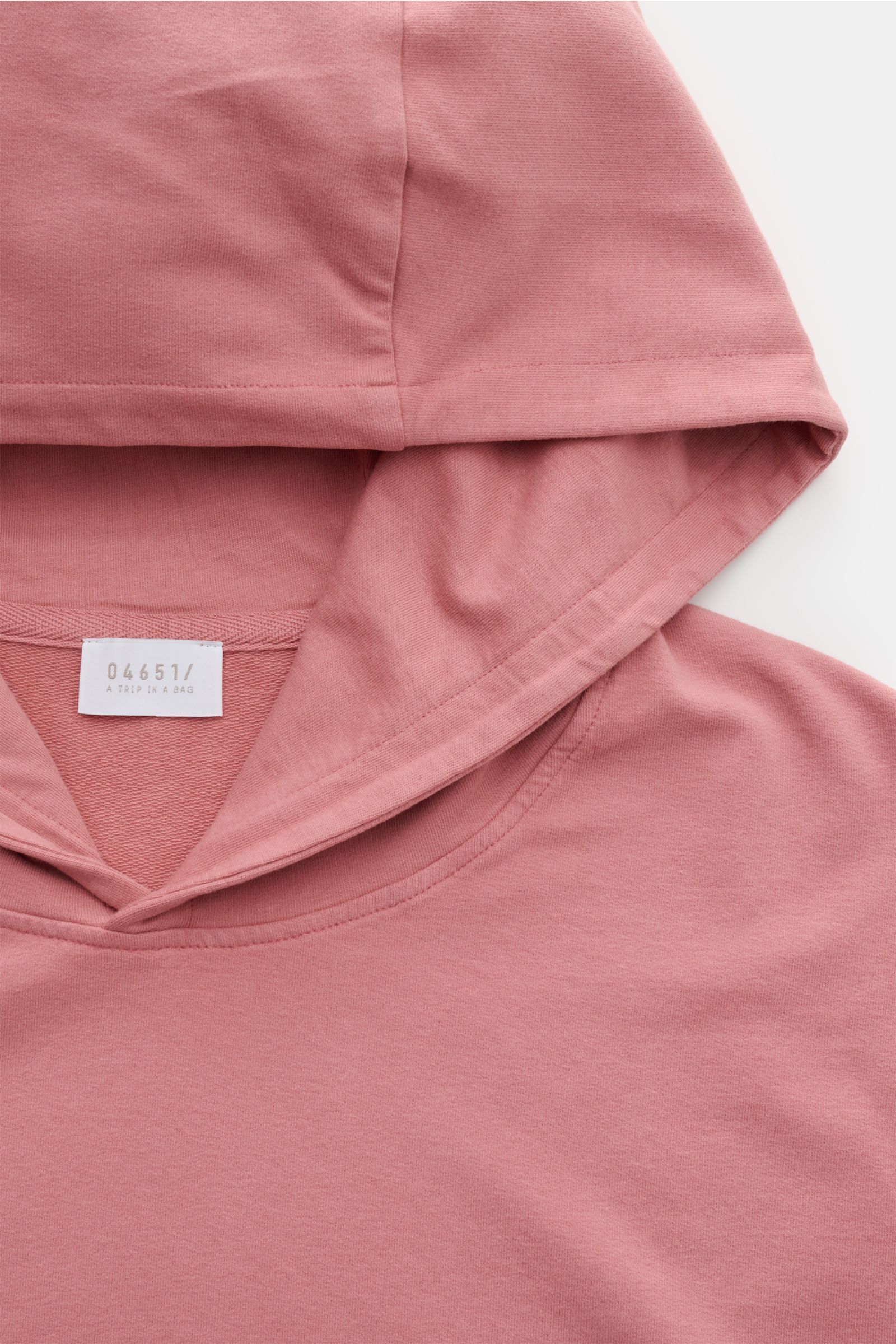 Close-up front view of the hood and neckline of the 04651/ A trip in a bag Hooded jumper 'IF Hoodie' antique pink in soft, stretchy cotton, showing brushed jersey fabric and label.