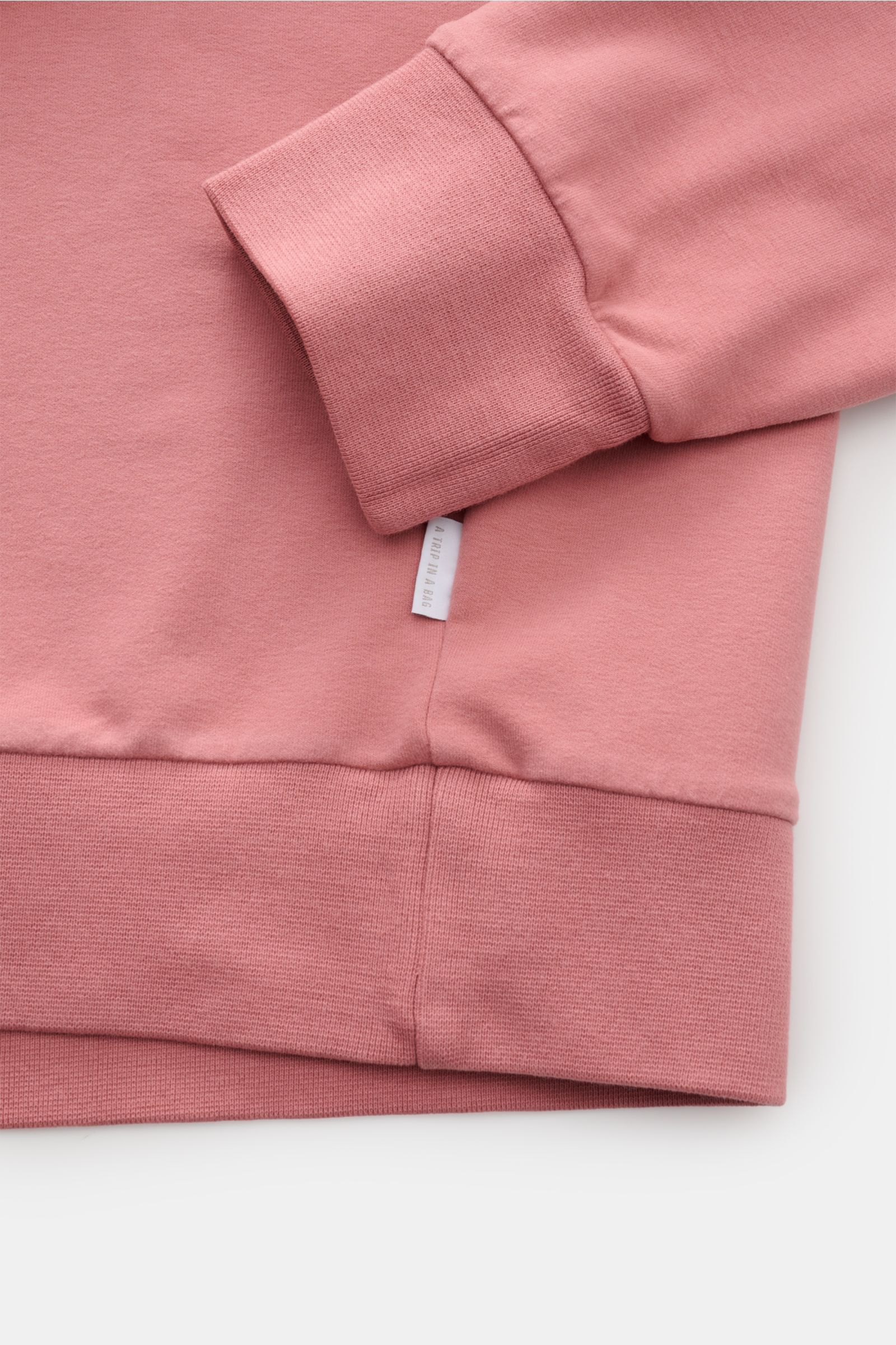 Close-up front view of the antique pink 04651/ A trip in a bag Hooded jumper 'IF Hoodie', showing ribbed cuffs, hem, soft stretchy cotton fabric, and small woven side label.