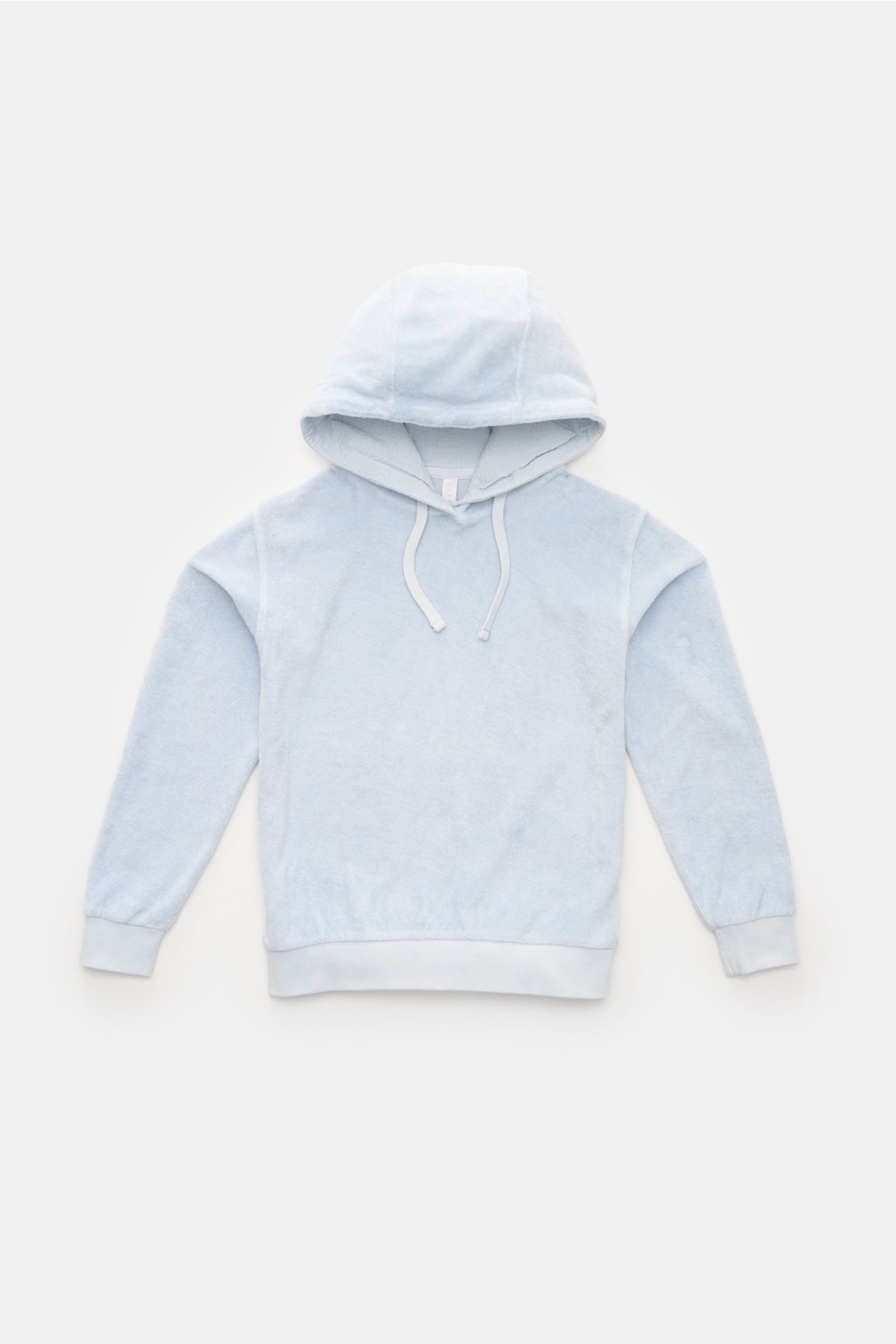 Front view of a light blue kids hoodie made of pure cotton fleece, soft texture, with hood and drawstrings, ribbed cuffs and hem, garment dyed, slim fit, featuring a small woven label in the side seam, named 04651/ A trip in a bag Kinder Fleece-Kapuzenpul