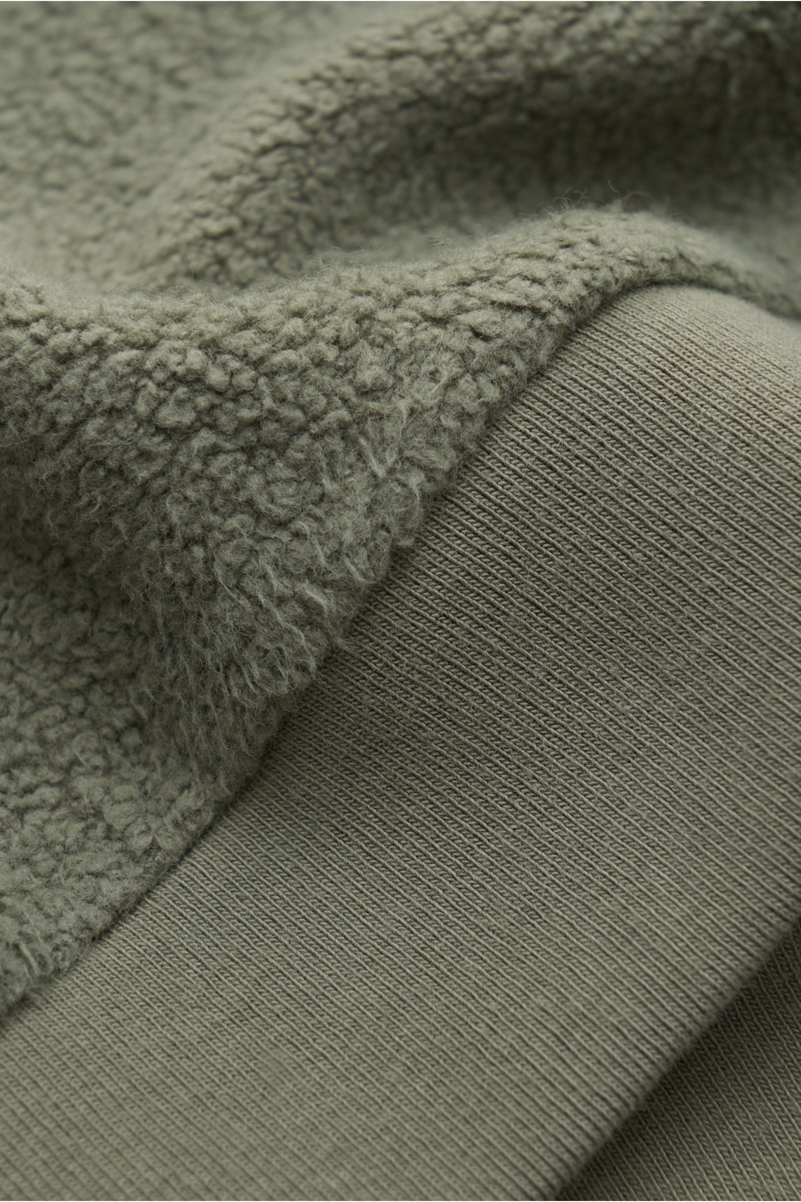 Nahaufnahme des olivfarbenen 04651/ A trip in a bag Kinder Fleece-Kapuzenpullovers 'Oyster Kids PF Hoody' mit weichem Baumwoll-Fleece und Rippbündchen.