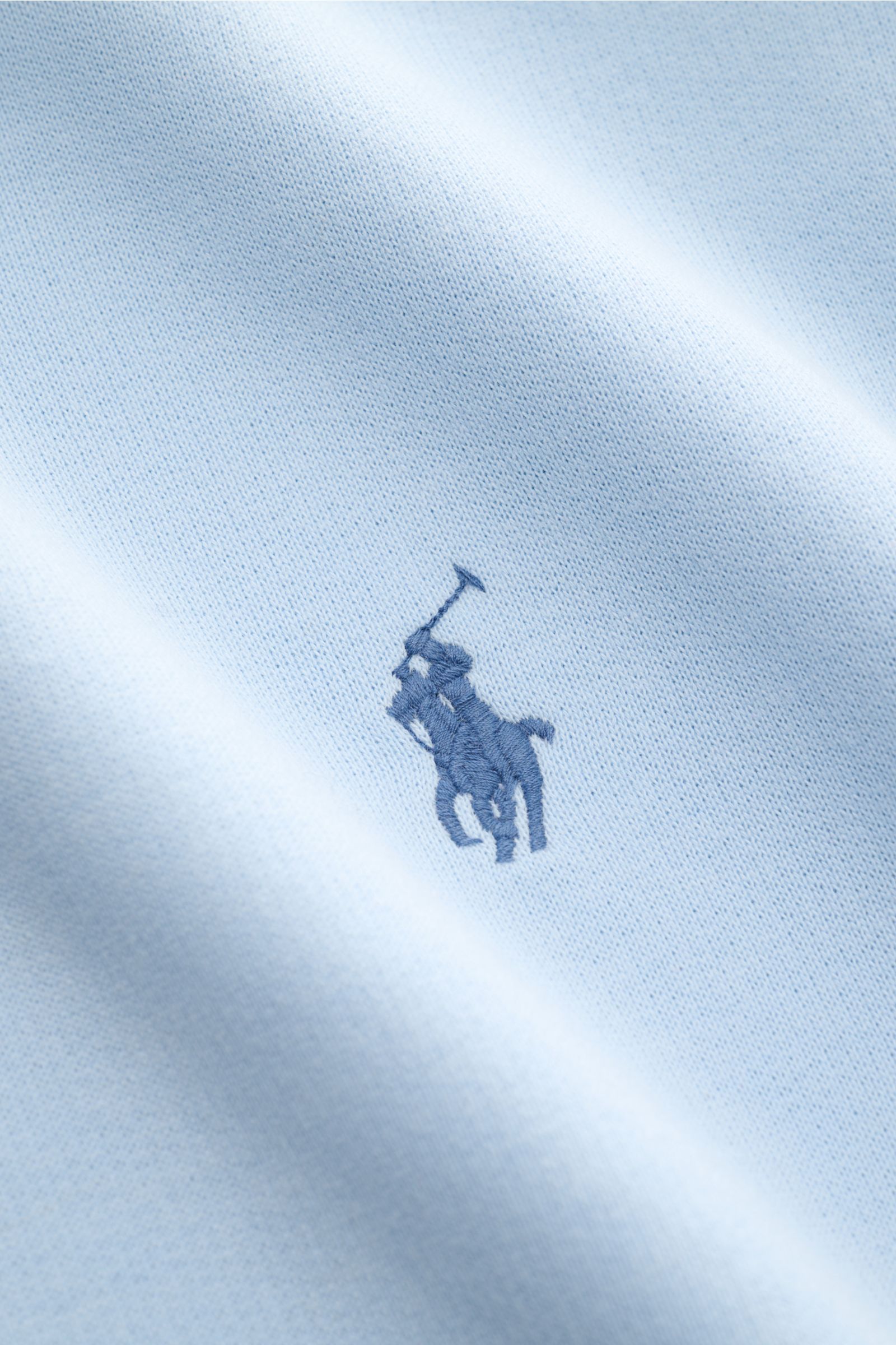 Nahaufnahme des Polo Ralph Lauren Kapuzenpullover hellblau mit Logo-Stick auf der Brust, Sweat aus Baumwolle und Microfaser, weicher Griff, Regular Fit, Kapuze mit Tunnelzug, Kängurutasche, angeraute Innenseite und elastische Bündchen.