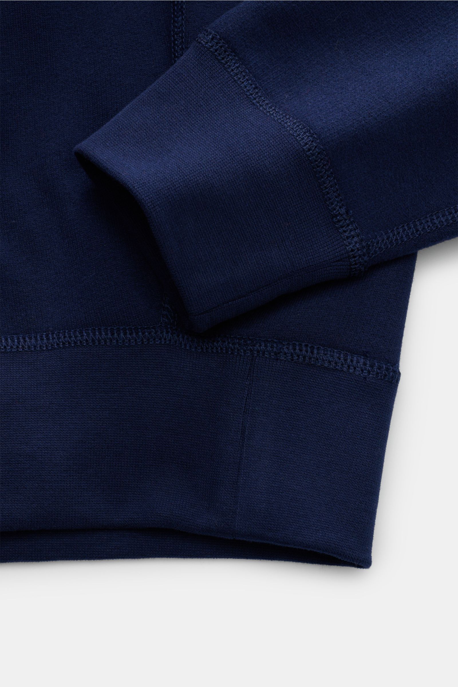 Nahaufnahme des Polo Ralph Lauren Kapuzenpullover navy von unten, Jersey aus Baumwolle und Microfaser, weicher Griff, Regular Fit, Kapuze mit Tunnelzug, Kängurutasche, typisches Logo-Stitching, angeraute softe Innenseite, breite Bündchen.