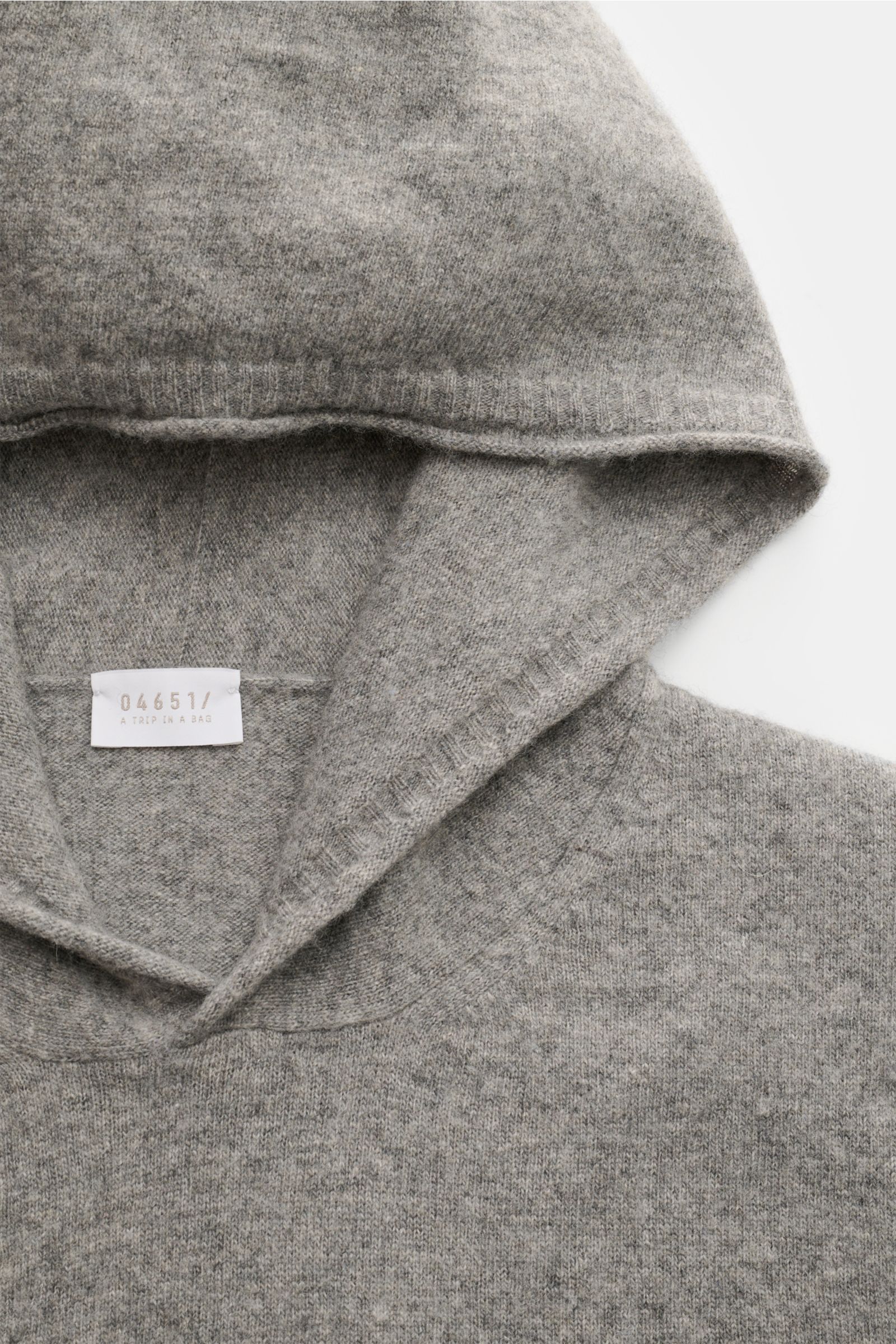 Close-up front view of the 04651/ A trip in a bag Kapuzenpullover sand, showing soft knit hood and fine wool, cashmere, viscose yarn with slim fit, comfortable ribbed cuffs, and detailed knit texture.