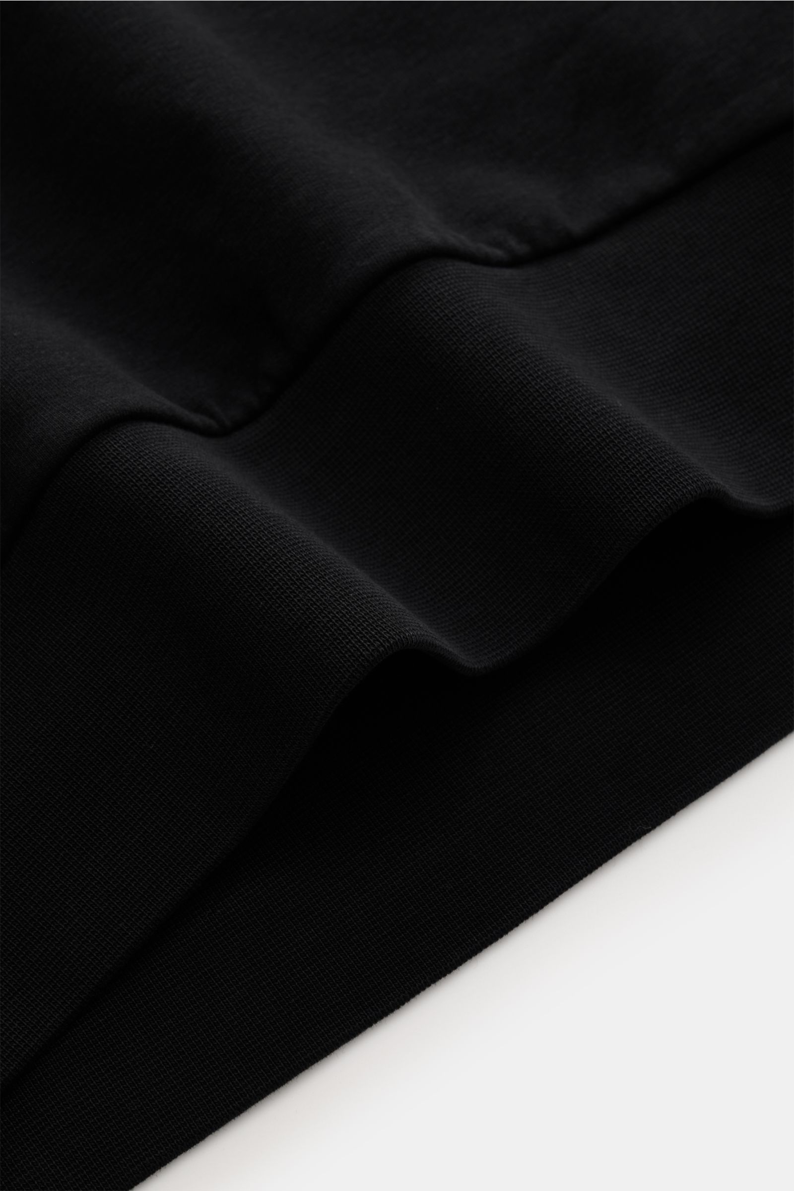 Close-up side view of the ribbed bands on the black 04651/ A trip in a bag Hooded jumper 'IF Hoodie' showing brushed jersey stretchy cotton fabric.