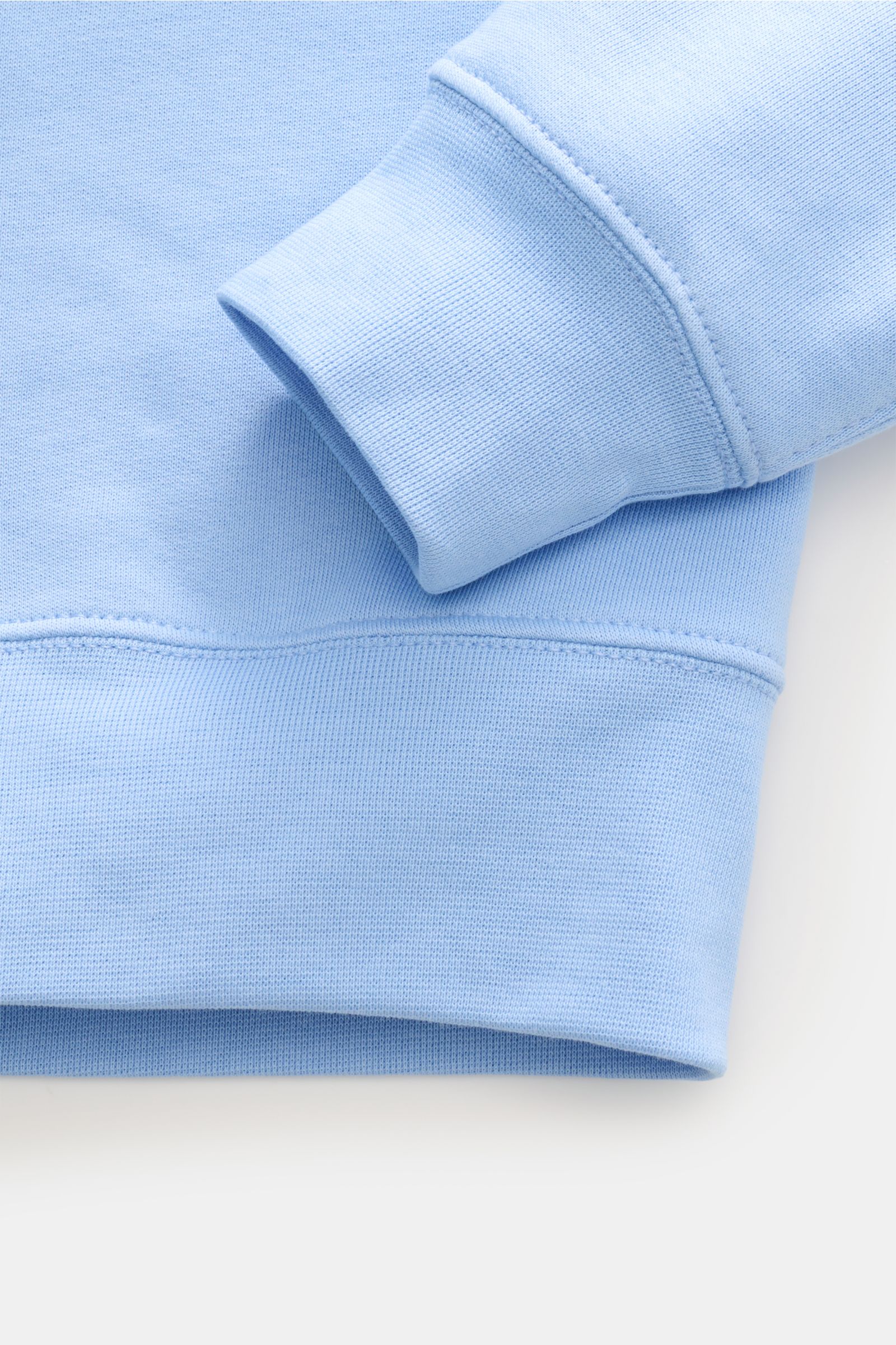 Polo Ralph Lauren Kapuzenpullover hellblau im Close-up, zeigt weichen Rippbündchen, Baumwoll-Microfaser-Mix und feine Nahtdetails.