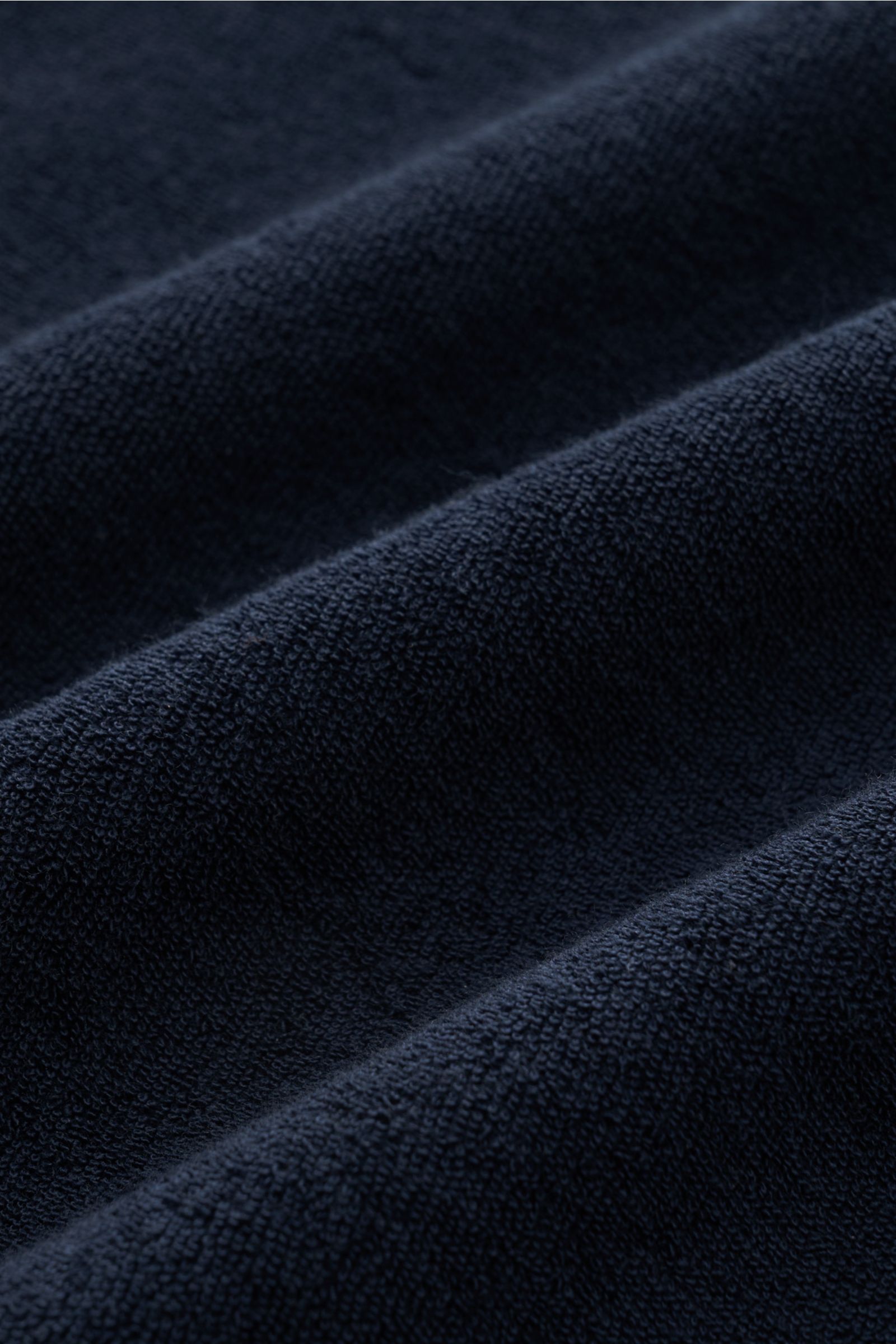 Close-up front perspective of navy terrycloth fabric showcasing texture of 04651/ A trip in a bag Terry hooded jumper 'Terry' navy.

Comfort and coolness with summery nonchalance: The hooded jumper 'Terry' by 04651/ A TRIP IN A BAG made of pure cotton 